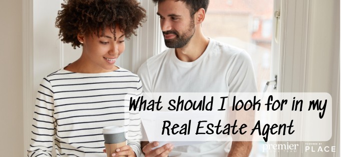 Couple looking at a checklist with the text :What should I look for in a Real Estate Agent