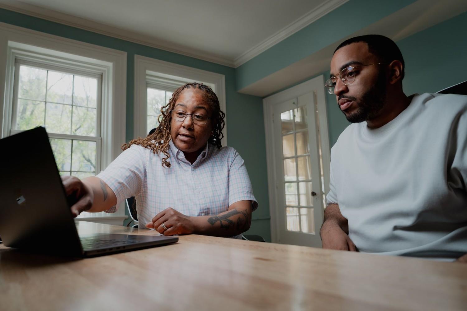 Premier Home Team real estate agents reviewing a closing disclosure and title insurance costs on a laptop in Philadelphia.