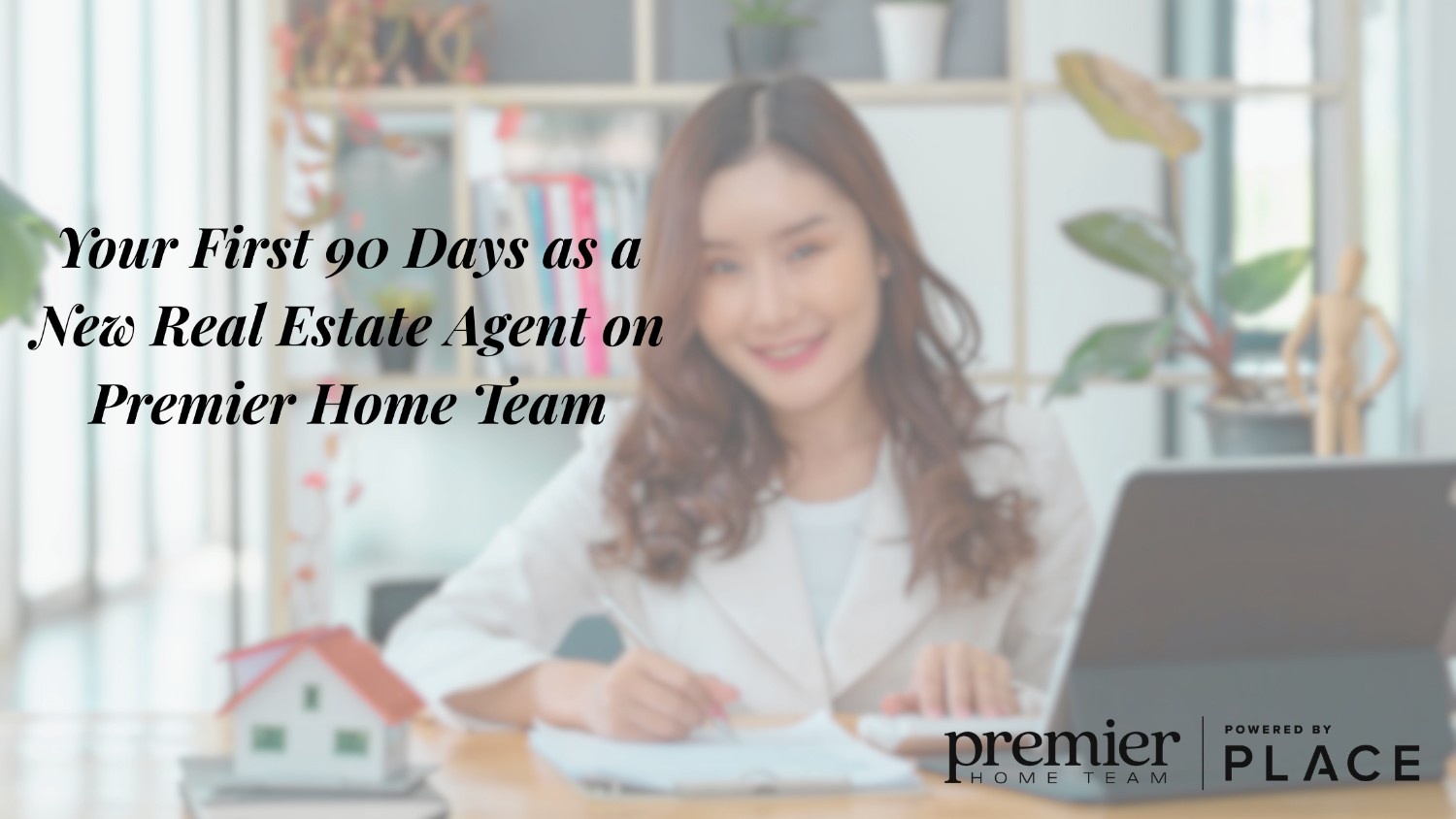 Real estate agent working at a table with a laptop and house model; text displayed is 