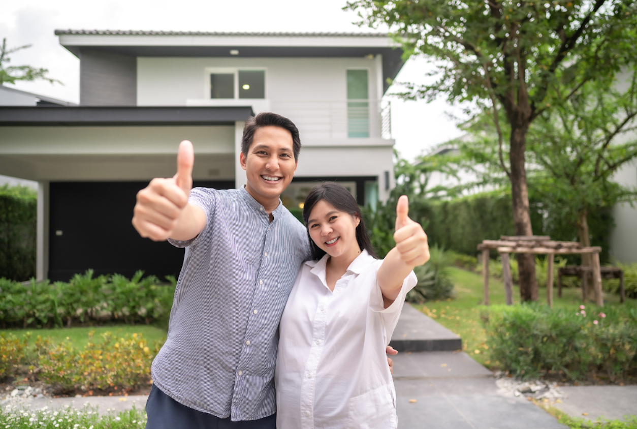 happy new homeowners in front of home