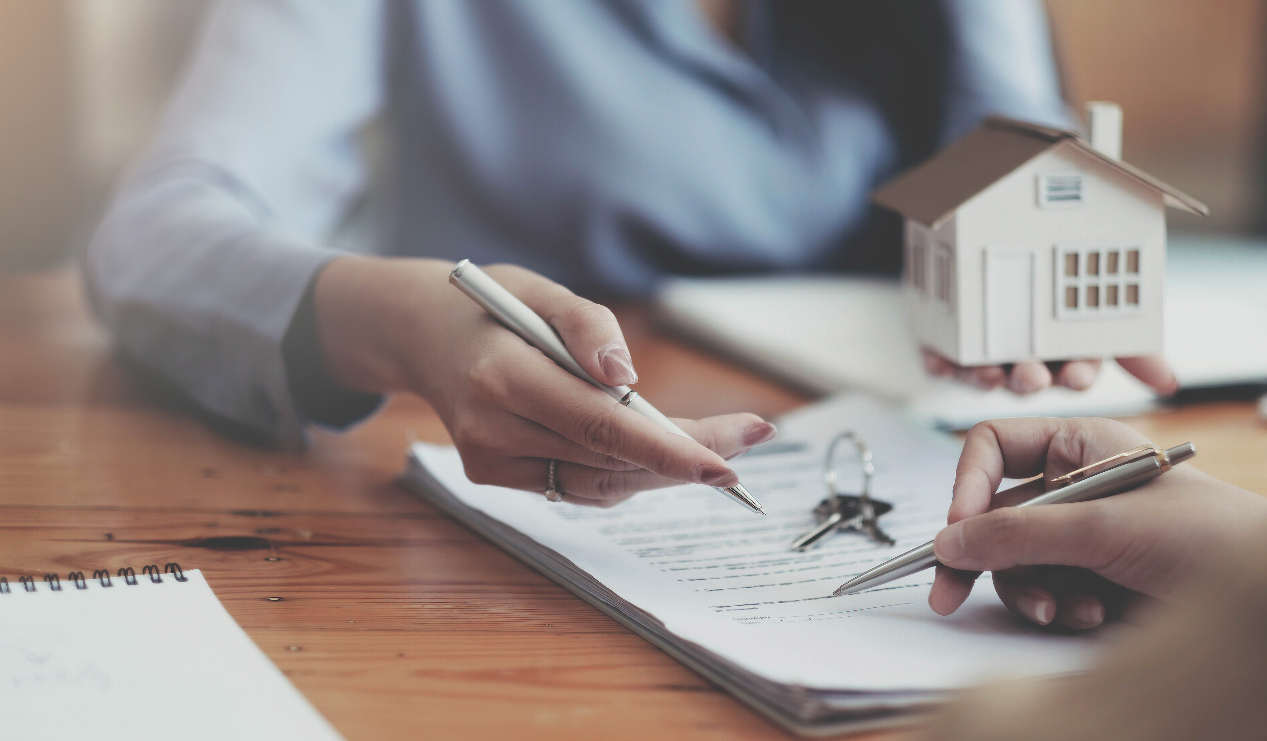 Close-up of mortgage documents and keys on a wooden table