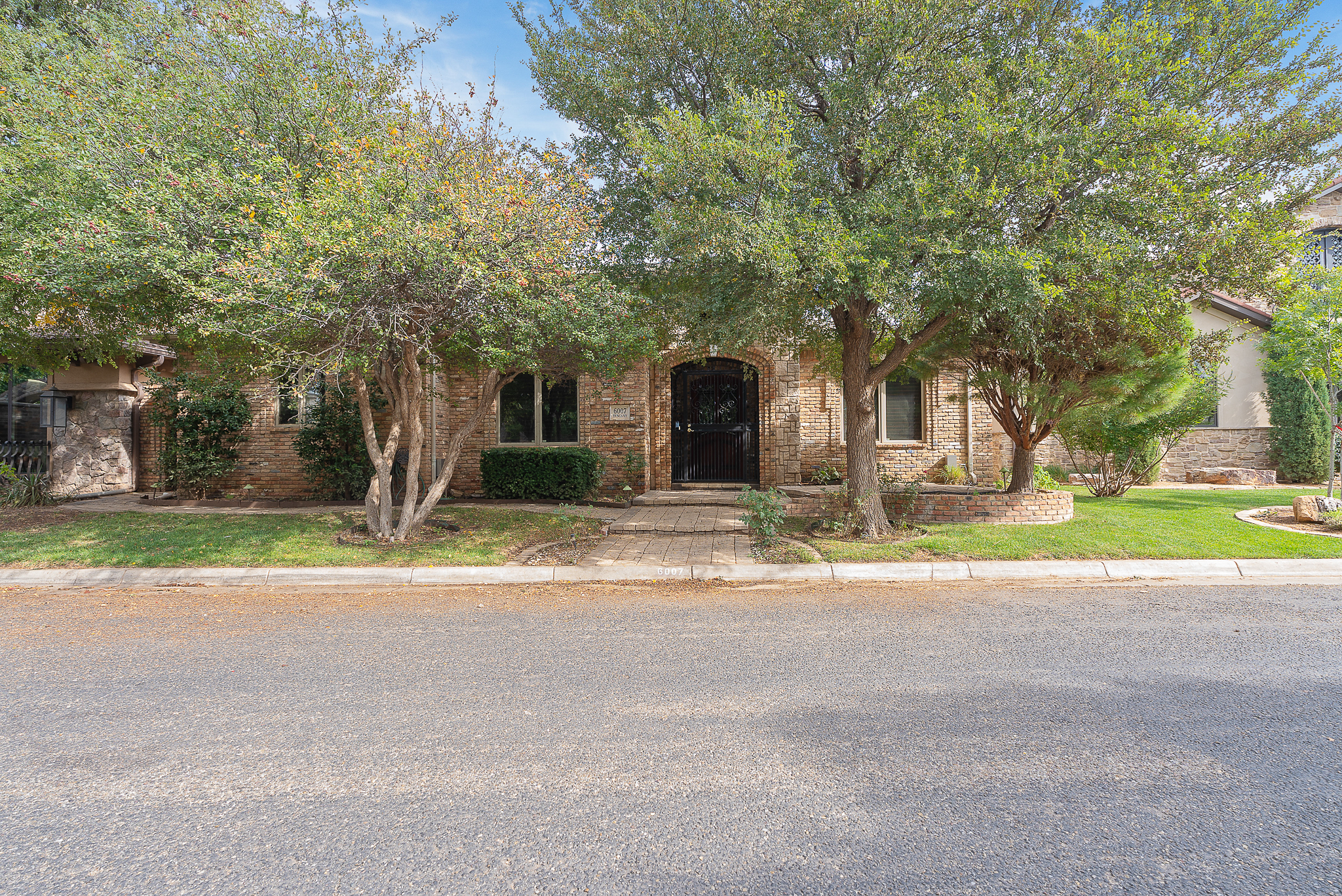 Front exterior of 6007 Tuscany Village Amarillo TX home with natural stone and brick