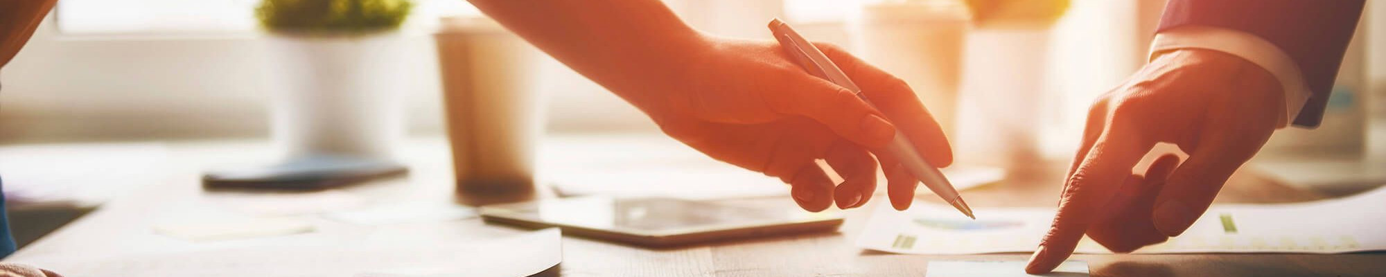 Hands reaching in to sign a document.