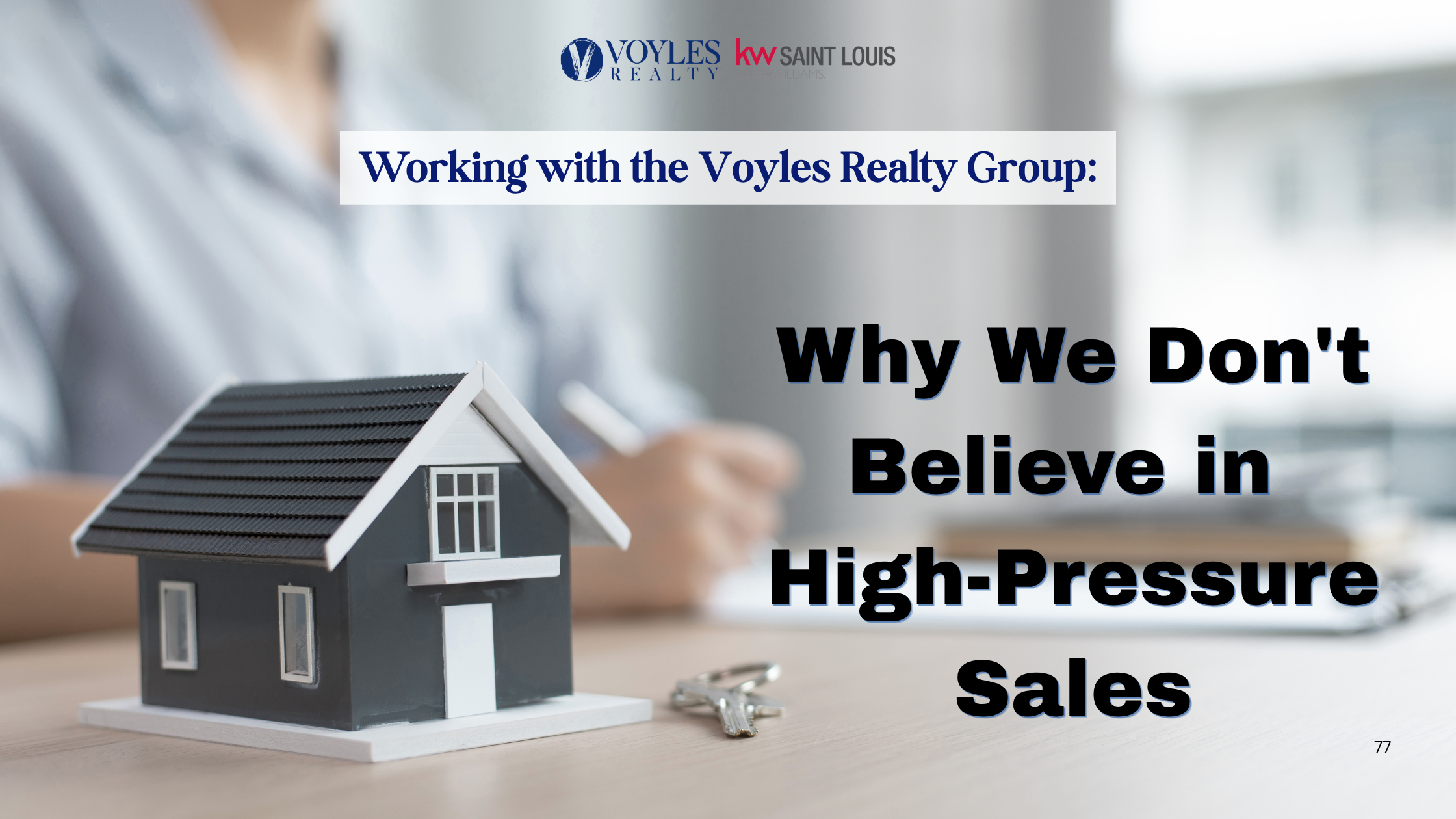A model house and keys on a desk with a blurred real estate agent writing in the background. Text overlay reads: Working with the Voyles Realty Group: Why We Don't Believe in High-Pressure Sales.