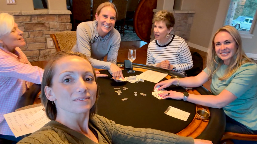 A group of Colorado ladies smiling around a table playing poker