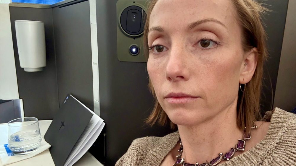 Two couples are sat around a table in a restaurant posing for a photo