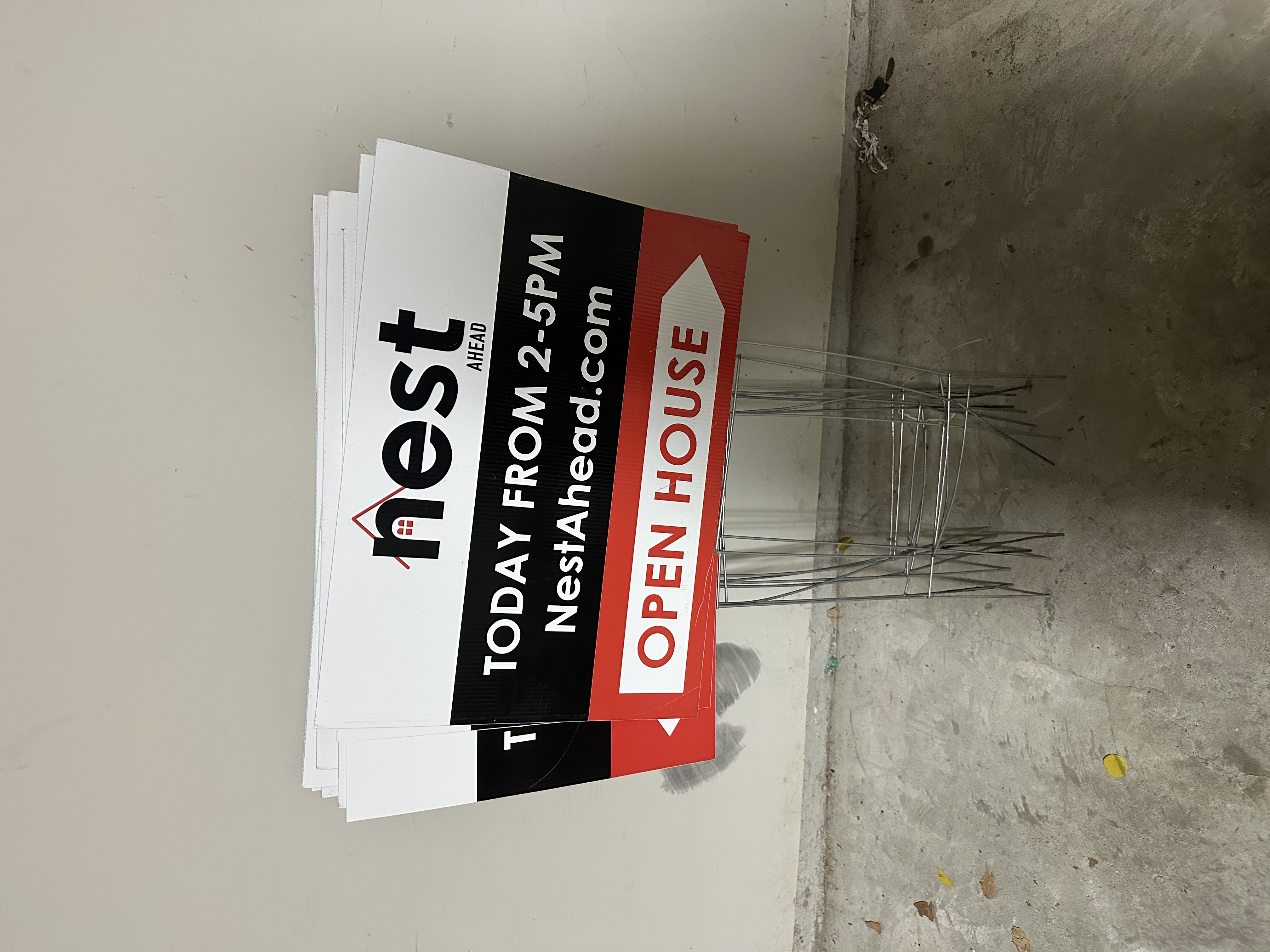 A REALTOR® welcoming prospective buyers to an open house in Katy, Texas. Picture of Nest Ahead's Open House signs.