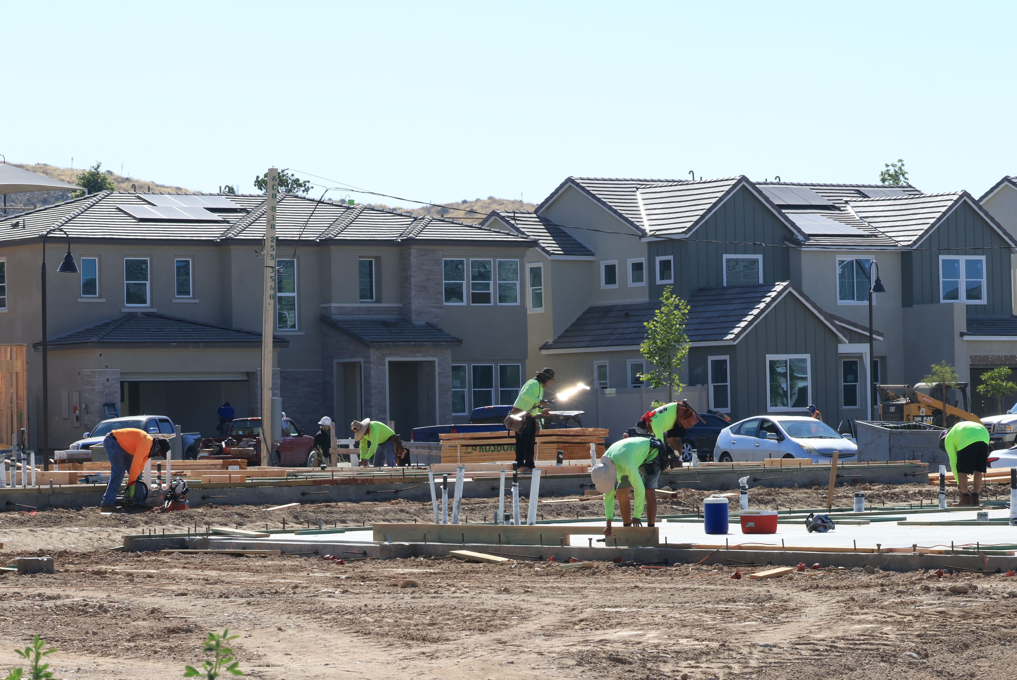 New construction home in Cape Coral, Florida, with modern architecture, fresh landscaping, and construction workers. Ideal for Southwest Florida real estate. 