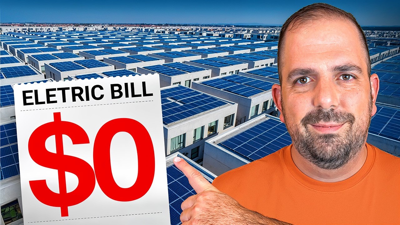 John Garuti smiling and pointing toward a large sign that says “Electric Bill $0,” set against an aerial view of a neighborhood covered in rows of rooftop solar panels.