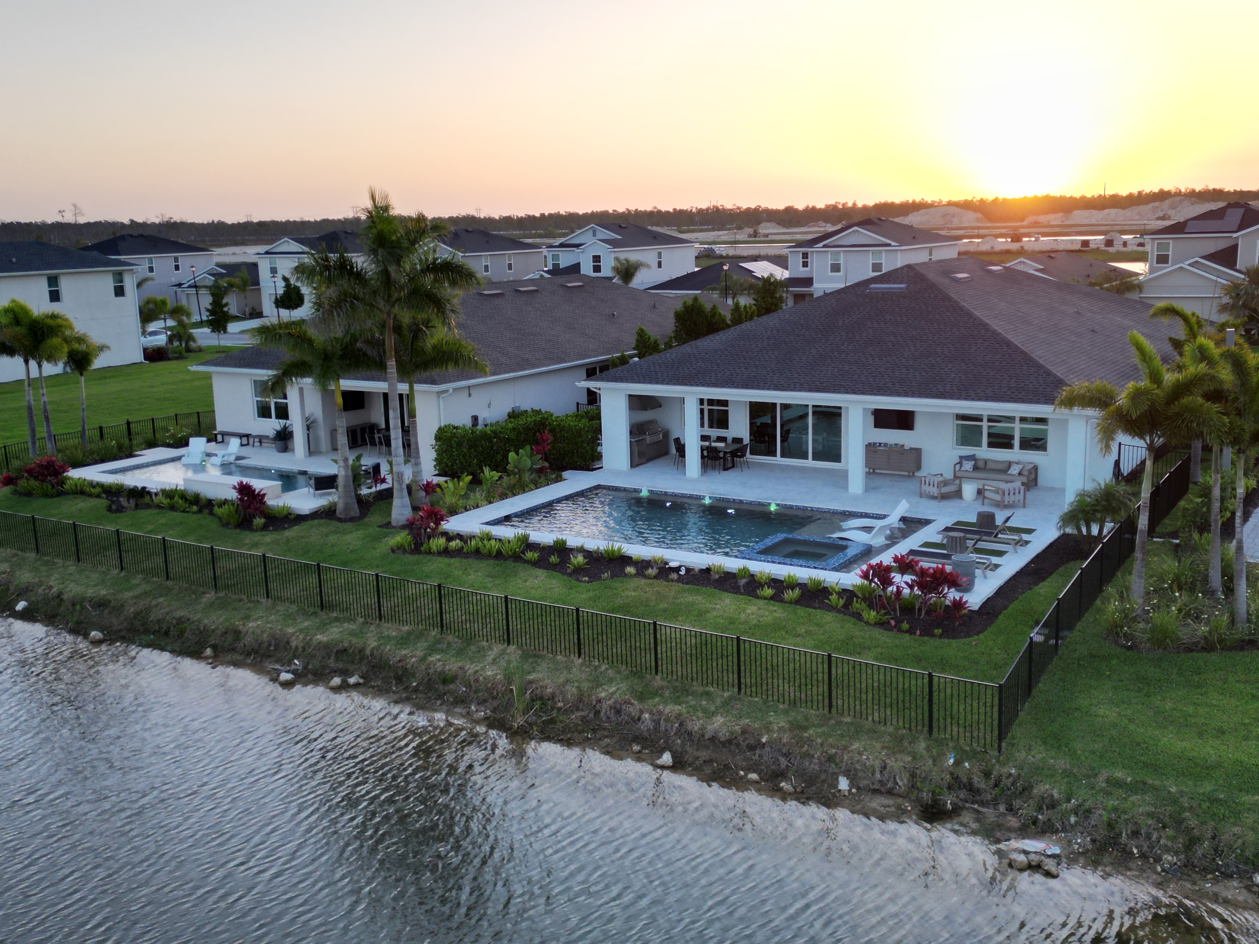 Beautiful waterfront home in Punta Gorda, Florida with private dock, boat lift, and tropical landscaping under a blue sky