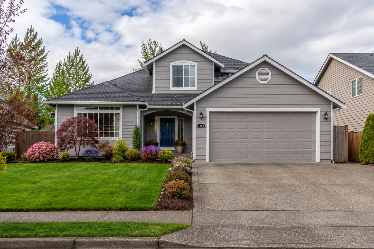 Home first impressions Salem OR — curb appeal with green lawn, clean driveway, and navy front door