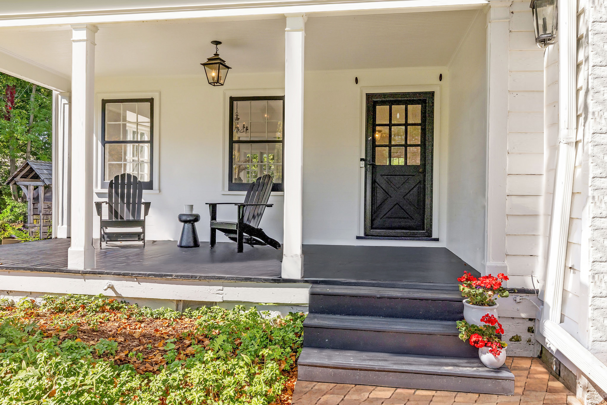 White front porch with black door and seating in a classic Milwaukee residential neighborhood