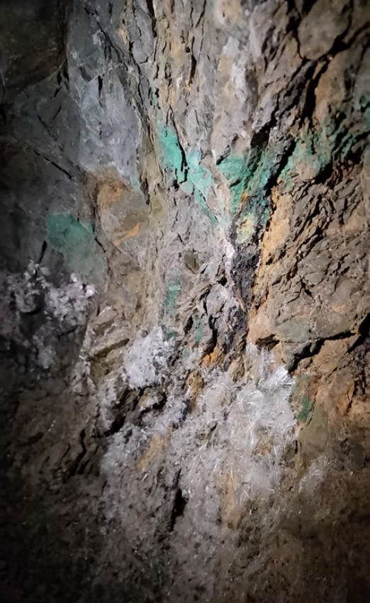 Narrow hand-dug tunnel entrance of historic Crystal Cave mine in Southern Utah desert hills