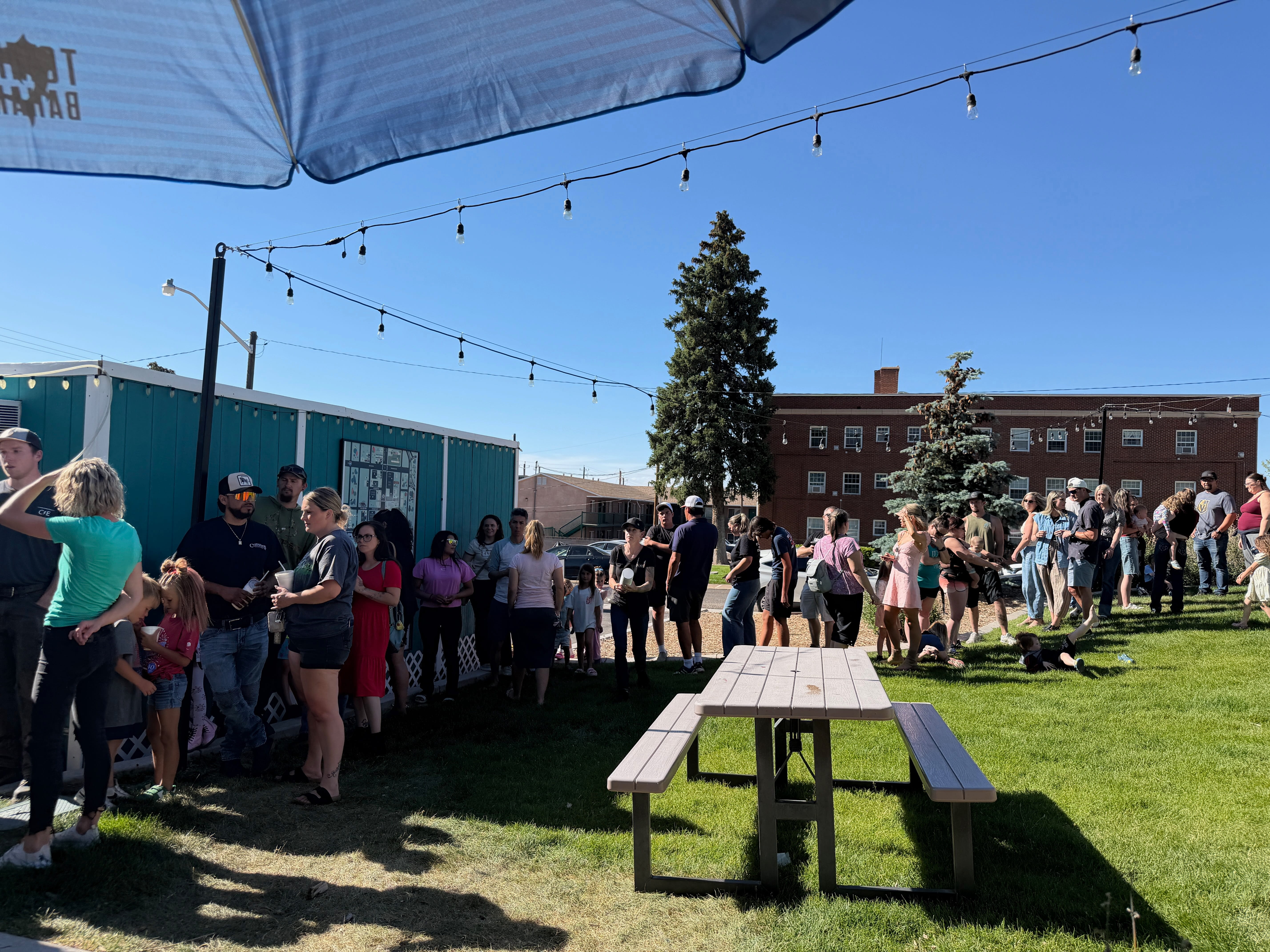 Community crowd lined up for free snow cones and sodas during Cedar City appreciation event hosted by local real estate team