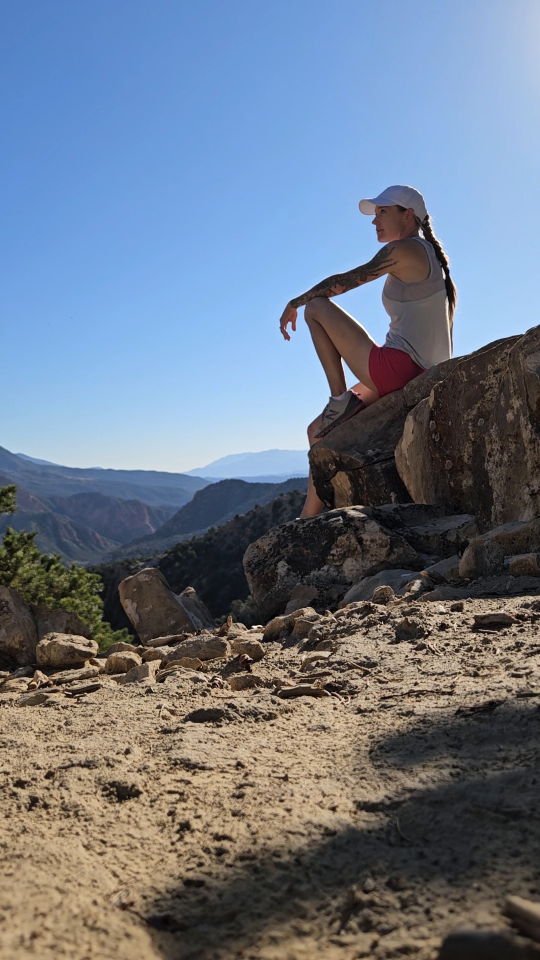 Author sitting on a boulder on Cedar City Lightning Switch Trail overlooking golf course and Thunderbird Gardens Trailhead access road