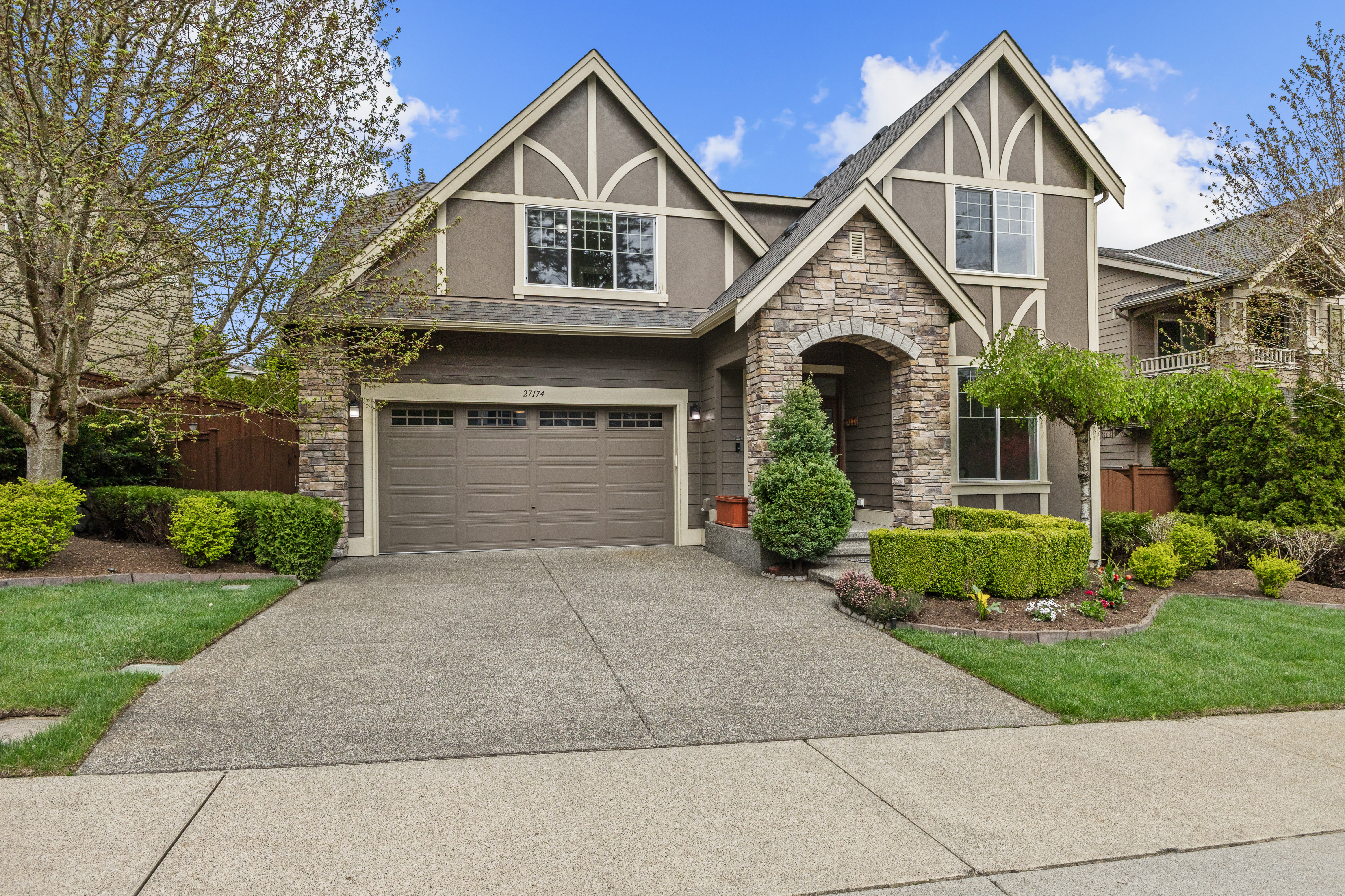 East-facing Tudor-style home exterior with stone accents and manicured landscaping in Trossachs, Sammamish WA