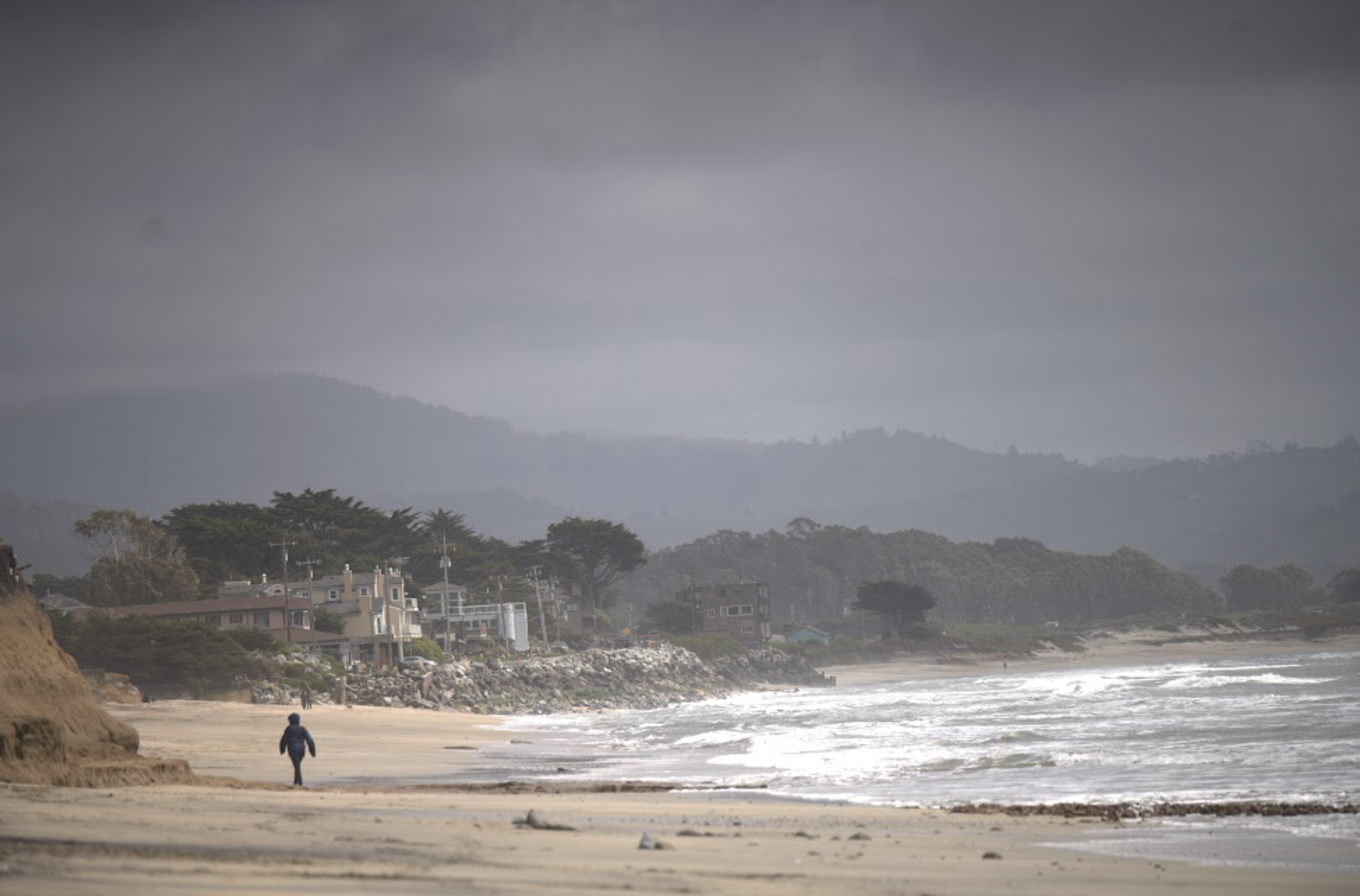 Person walking on the beach on the coast