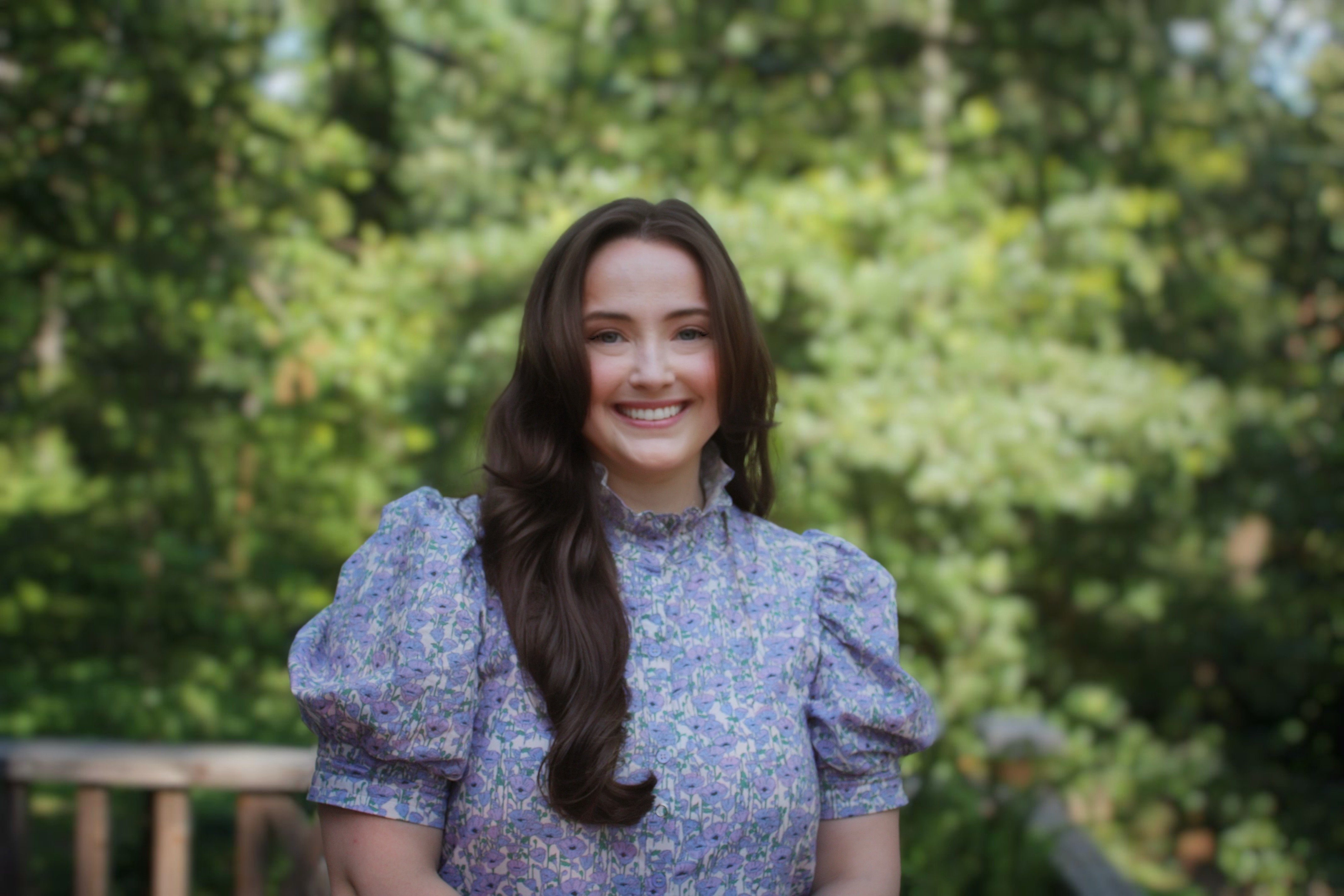 female real estate agent outside smiling with dark hair and dress