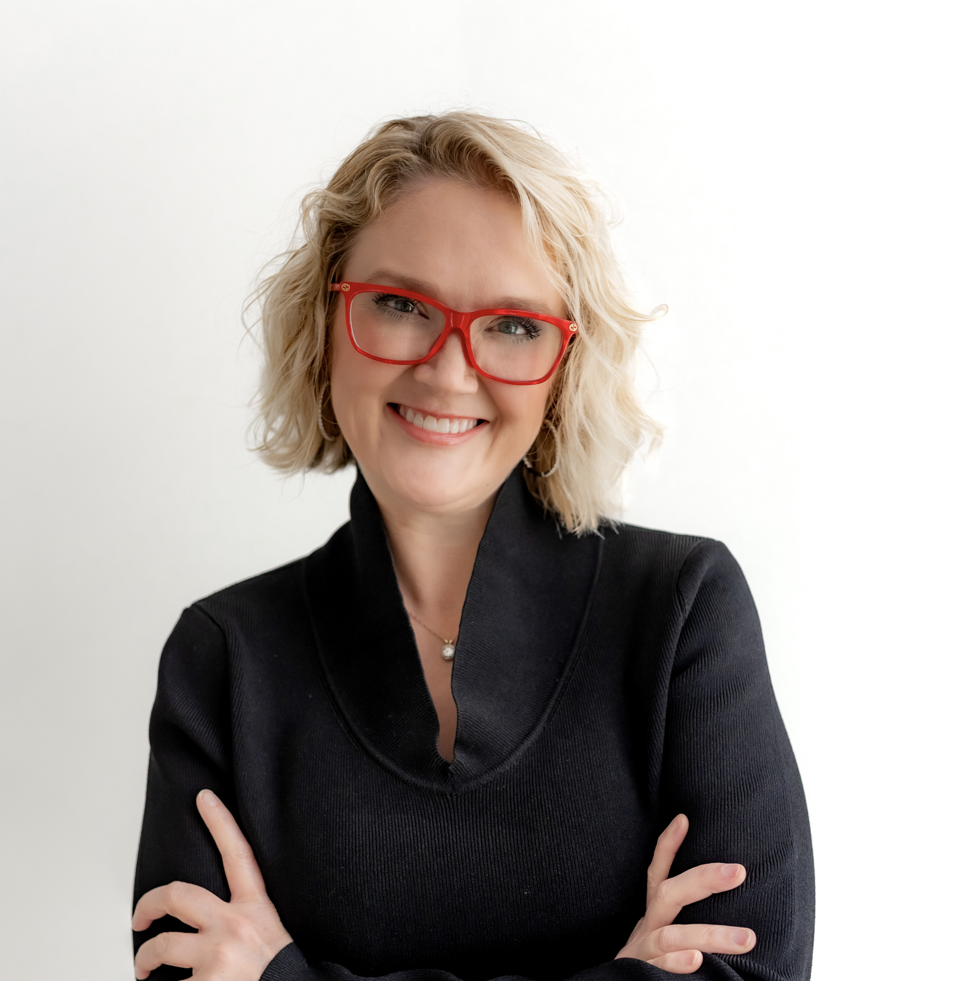 hometown real estate agent, female business owner in black blouse with red glasses