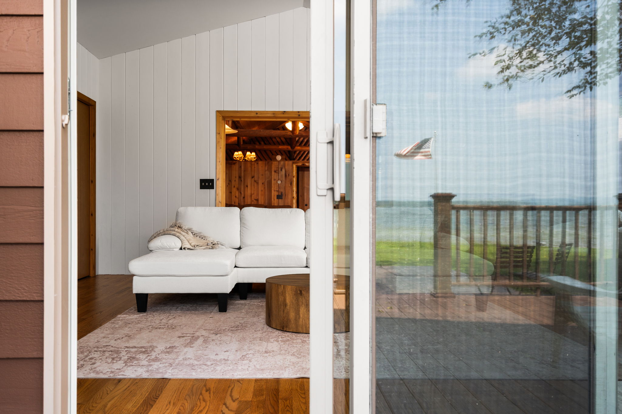Spacious sitting room with large windows and door overlooking Northern Michigan water