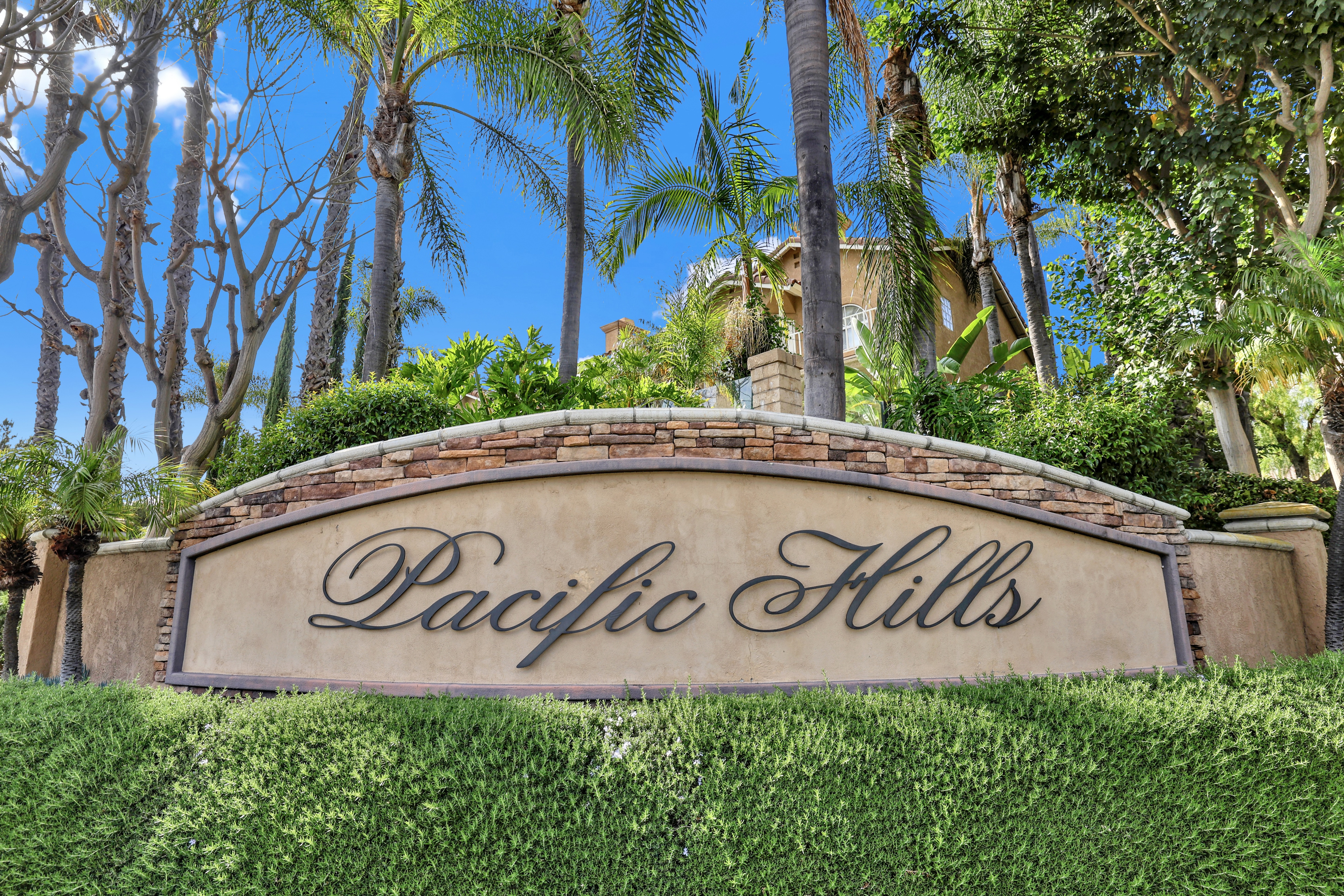 Pacific Hills community entrance sign in Mission Viejo, California, with palm trees and Mediterranean homes in background
