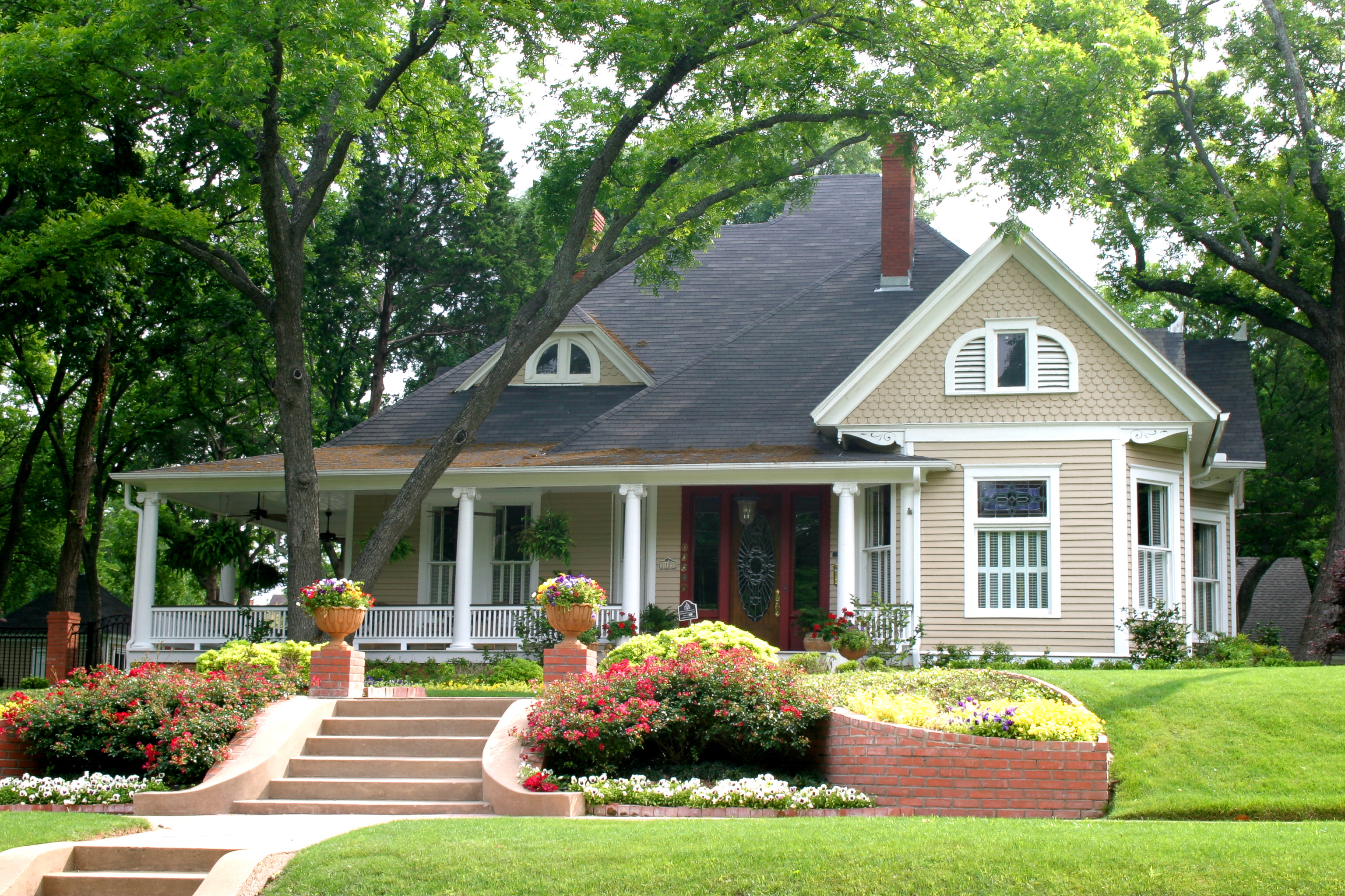 beige house with pink bushes