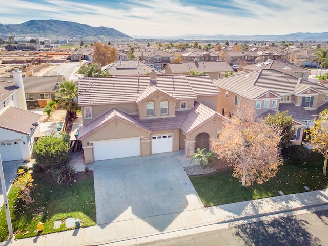Exterior view of a single family home at 26599 Opal in Moreno Valley CA  featuring a spacious yard and mountain backdrop
