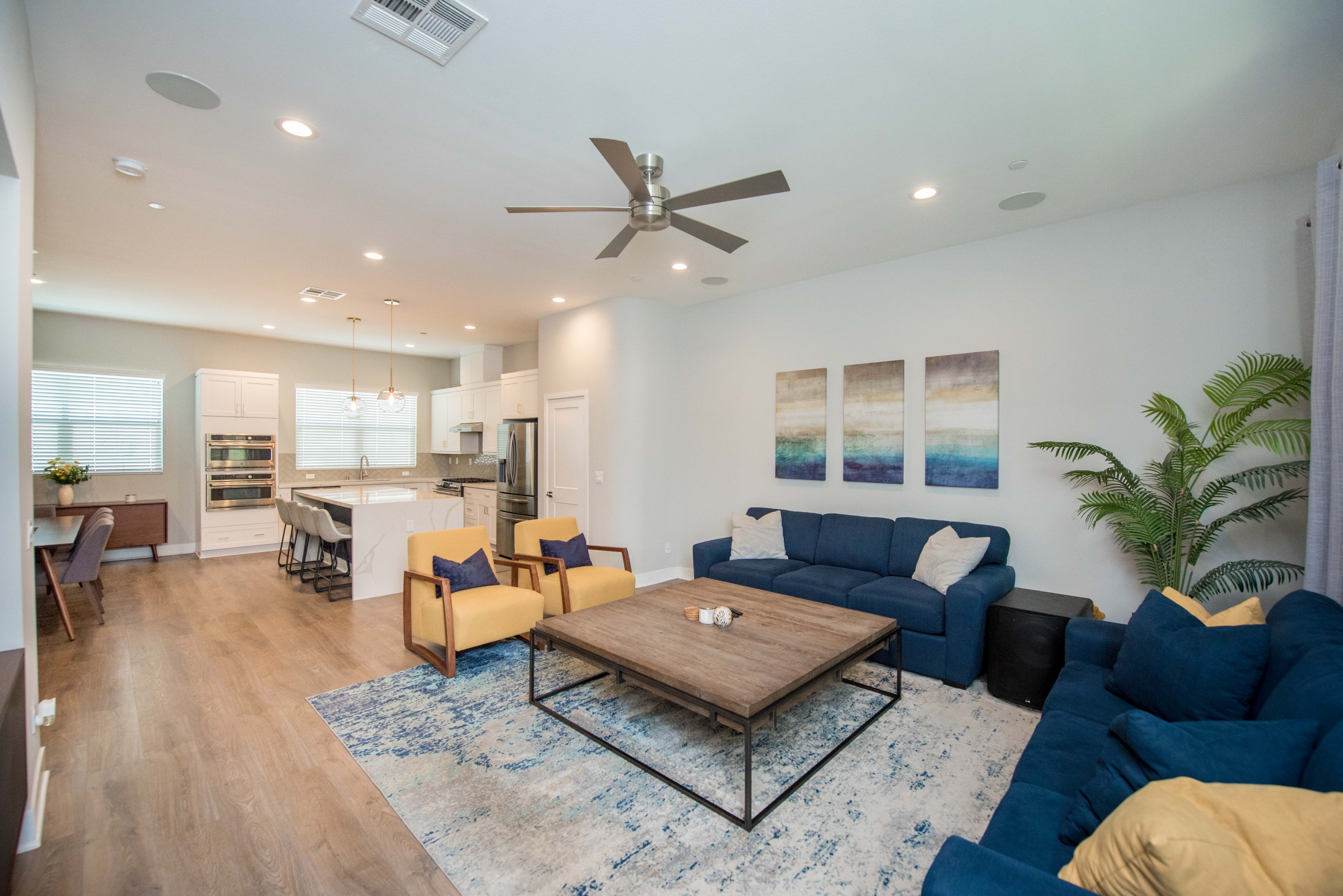 Spacious open-concept living room at 983 E Mason Lane #123 in Anaheim with adjoining kitchen, dining area, wood-look flooring and abundant natural light.