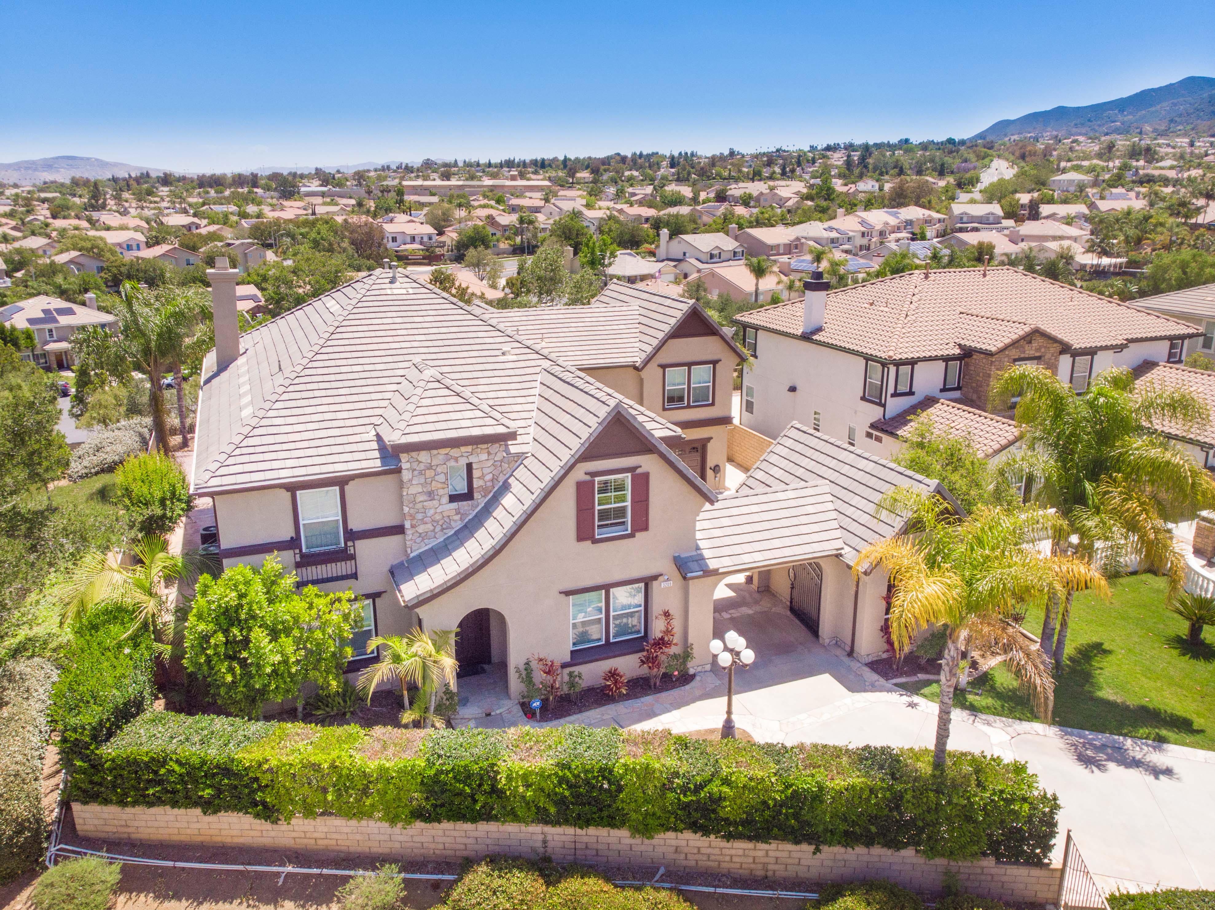3209 Stoneberry Lane in Corona featuring a spacious corner lot, private motor court, and elevated views within the desirable Sky Ranch neighborhood.