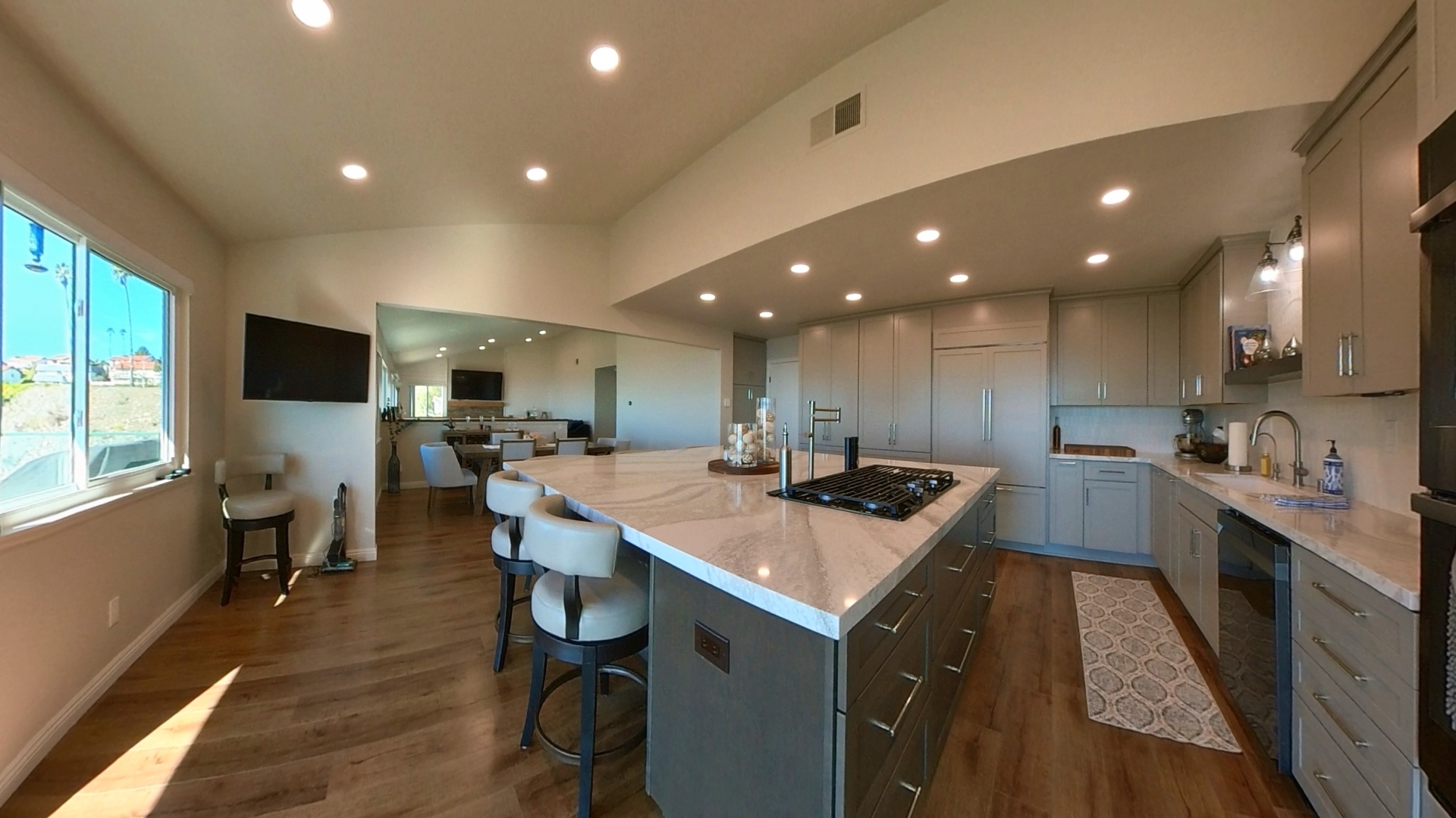 Updated chef’s kitchen at 31311 Marne Drive in Rancho Palos Verdes featuring an oversized stone island, custom cabinetry, built-in appliances, wood flooring, and abundant natural light