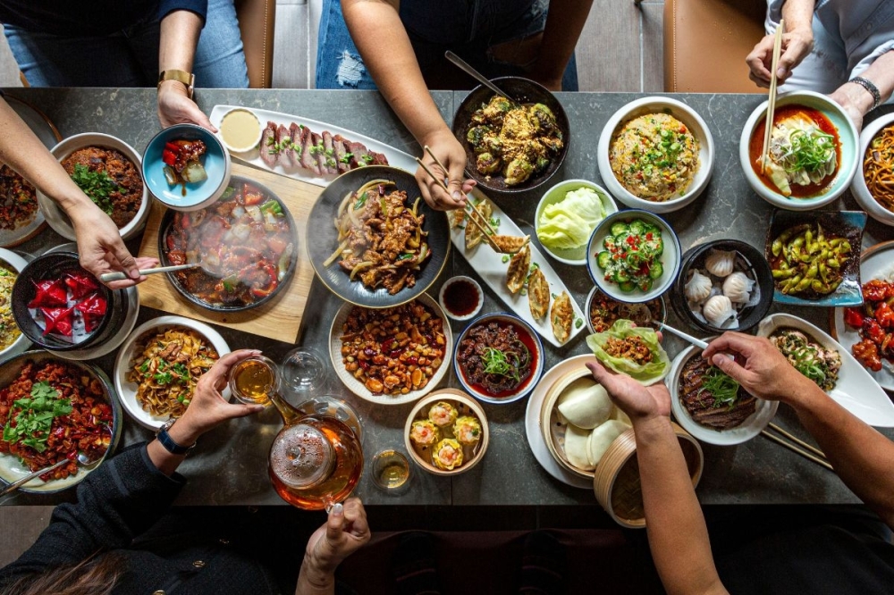 Third Duck N Bao location in Rice Village opens, highlighting elements of Chinese cuisine By Community Impact header image.