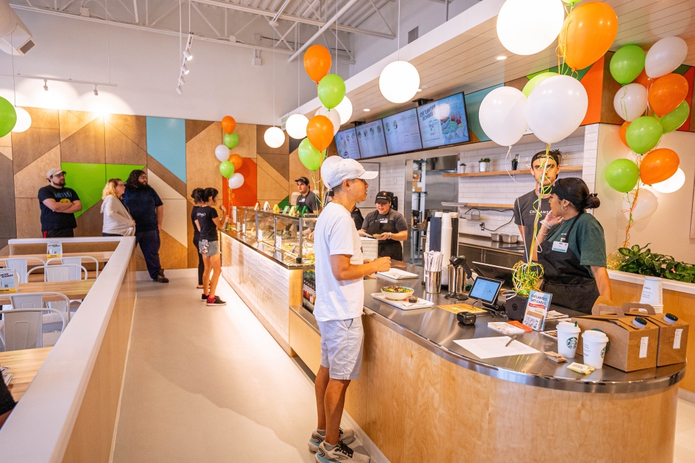 Chi’Lantro BBQ officials celebrate grand opening of Vintage Park restaurant By Community Impact header image.