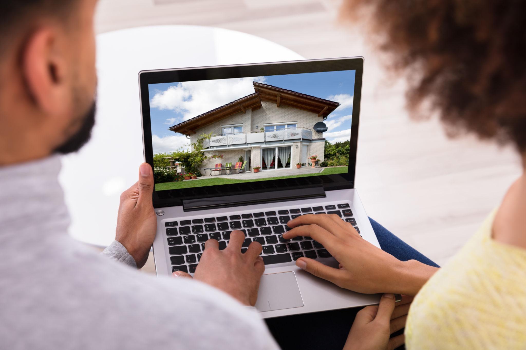 home buyers viewing real estate listing on laptop