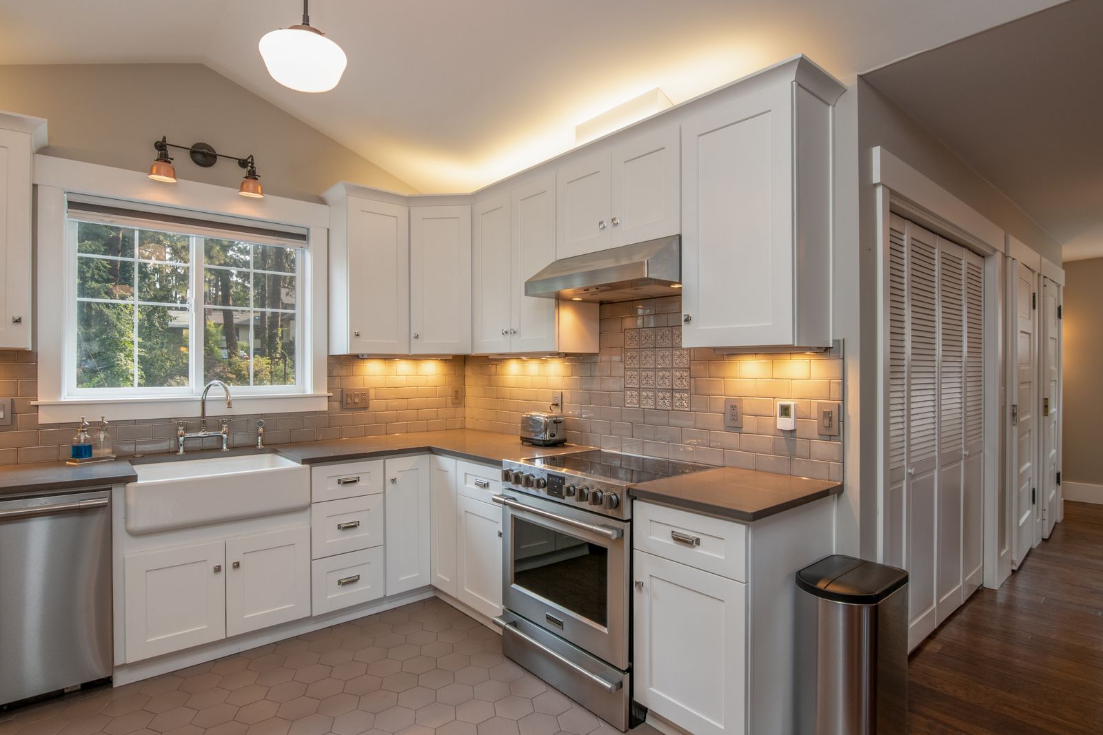 Updated white shaker kitchen with farmhouse sink, subway tile and stainless range - what to fix before selling your NH home