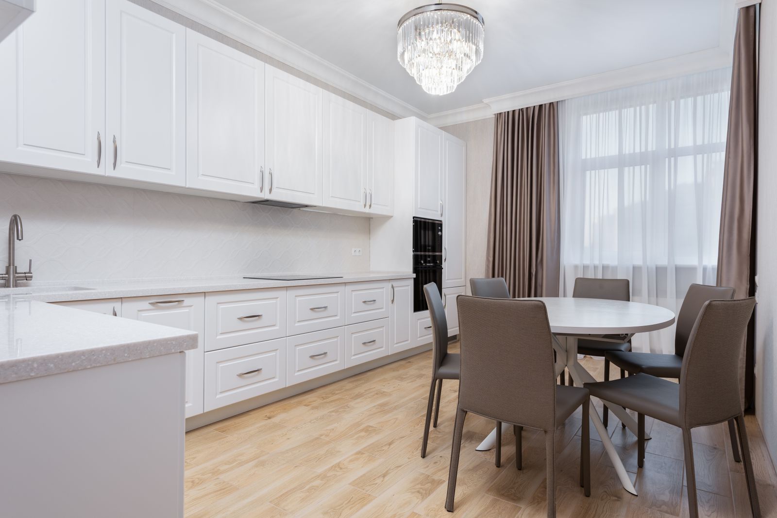Bright white kitchen opening to a sunlit dining area in a move-in-ready New Hampshire home