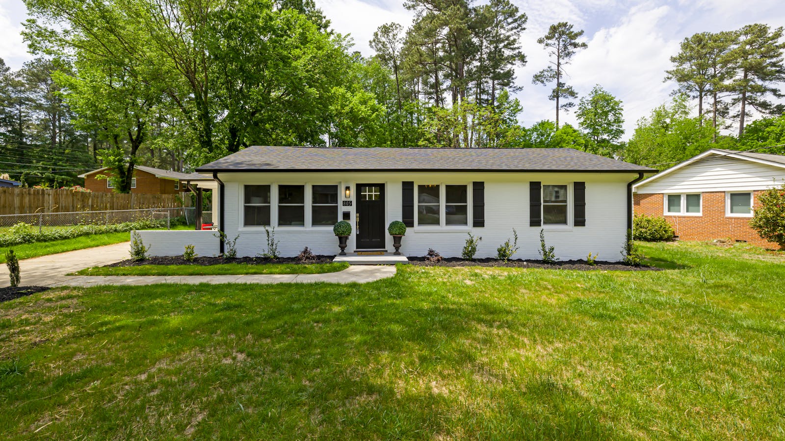 Charming single-story New England home with mature trees and landscaped front yard in Goffstown, NH