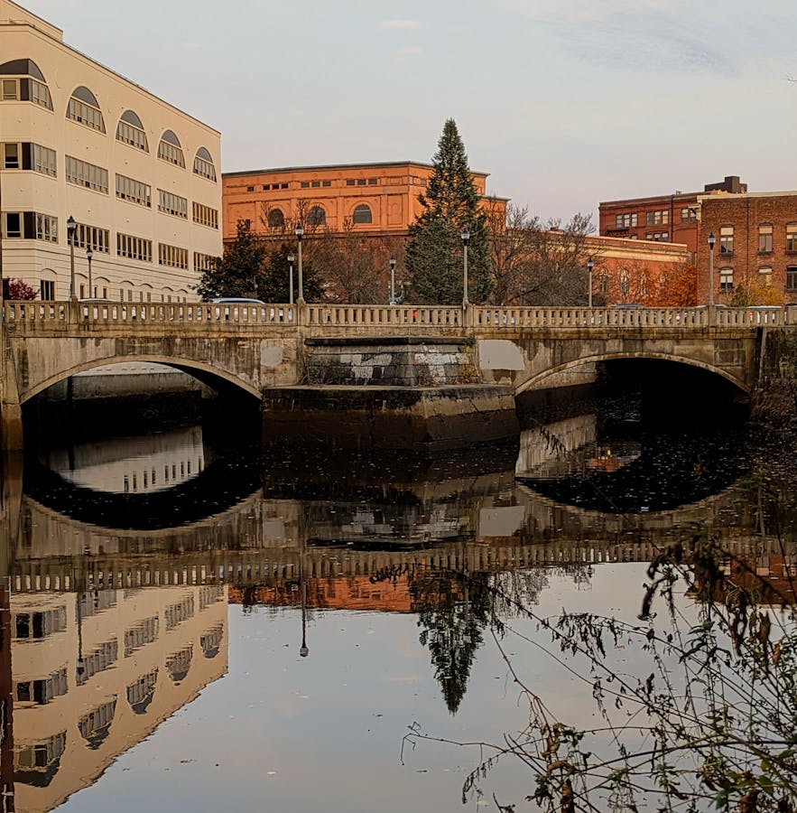 Downtown bridge over a calm river at daytime — Manchester NH real estate market update from The Phinney Team