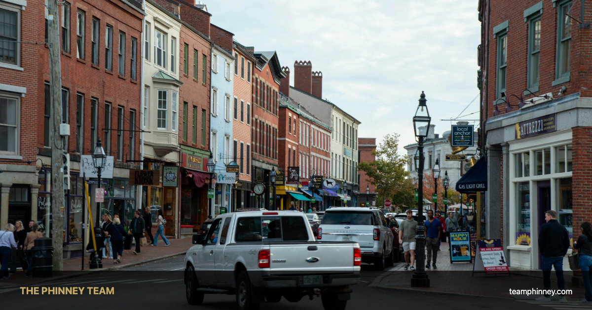 Bustling downtown New Hampshire street scene with brick storefronts — Nashua NH real estate spring 2026