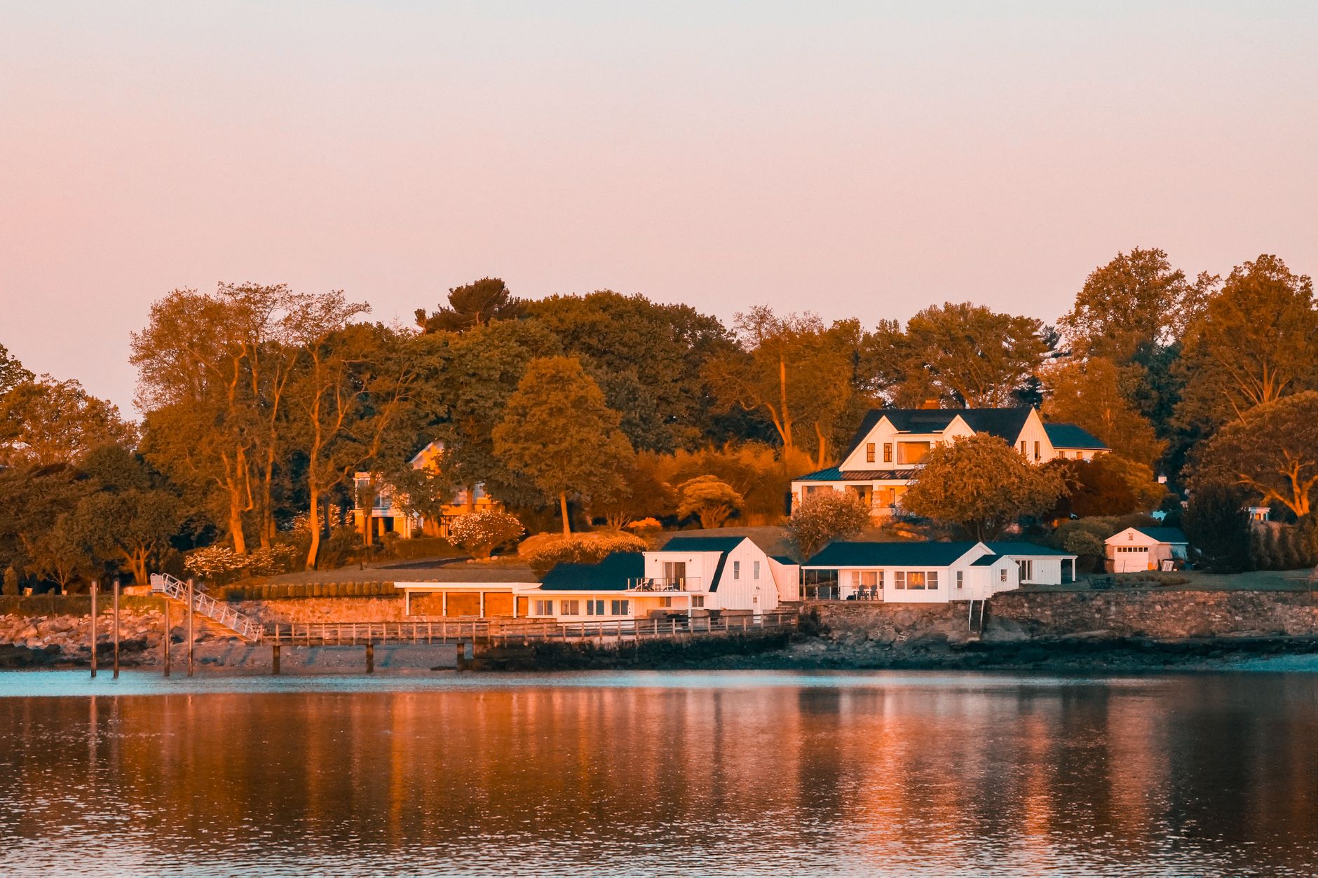 Waterfront New England luxury home at golden-hour sunset, jumbo loan territory in New Hampshire