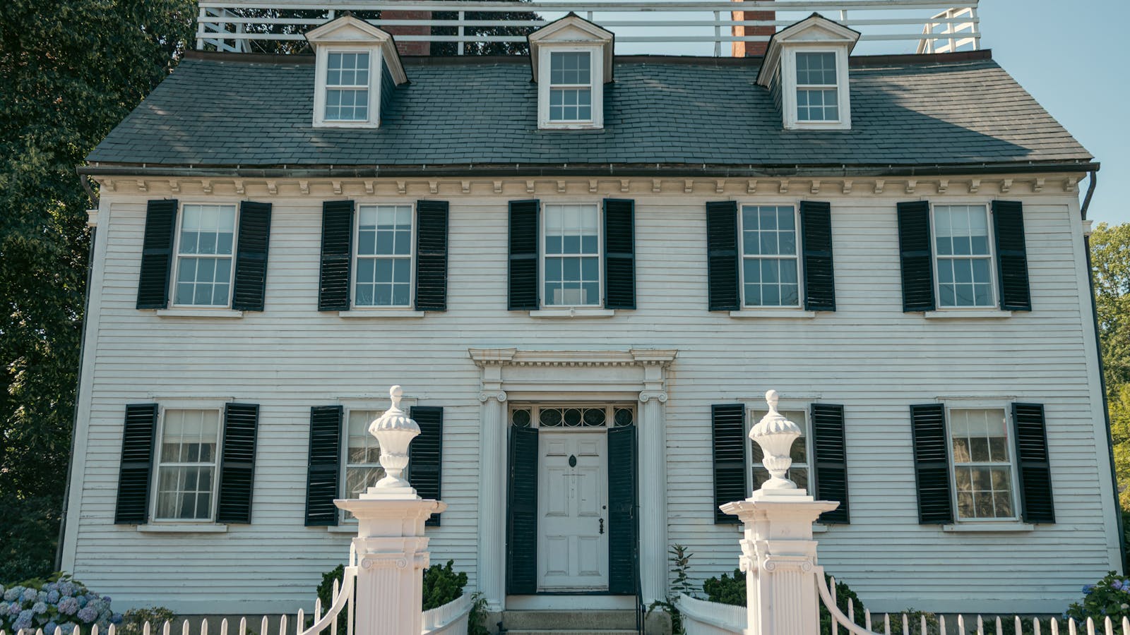 New England colonial home in Bow NH with mature trees and traditional clapboard exterior
