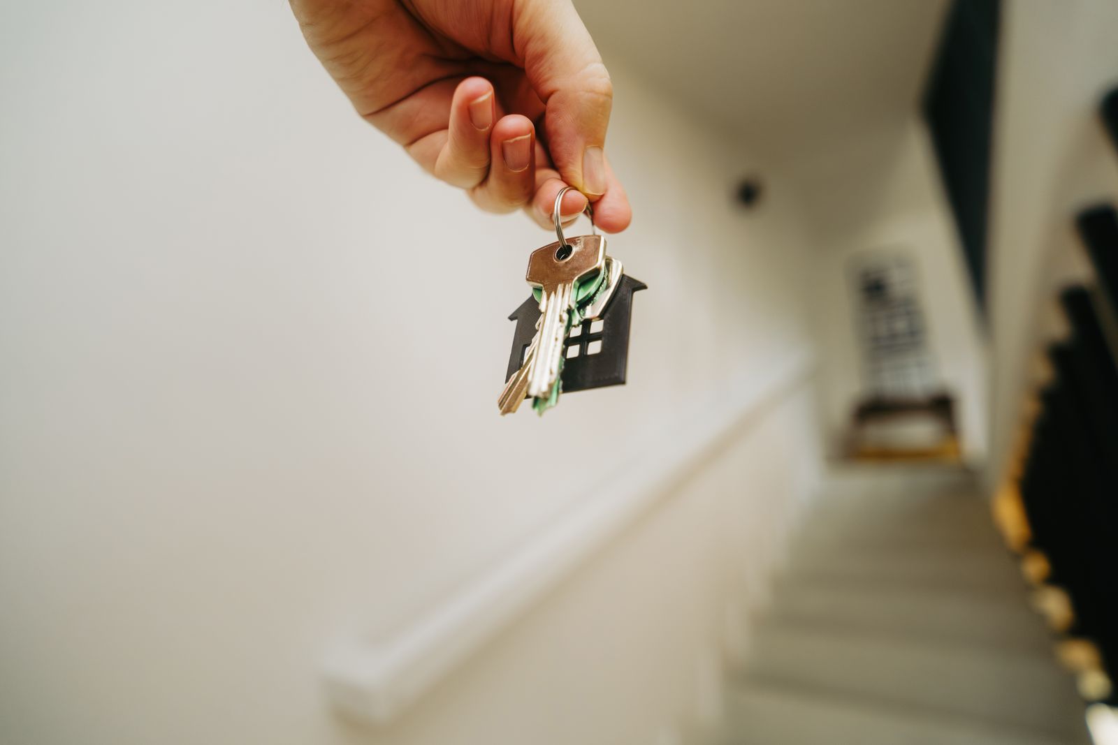 Hand holding a house keychain — choosing a New Hampshire town as a remote worker