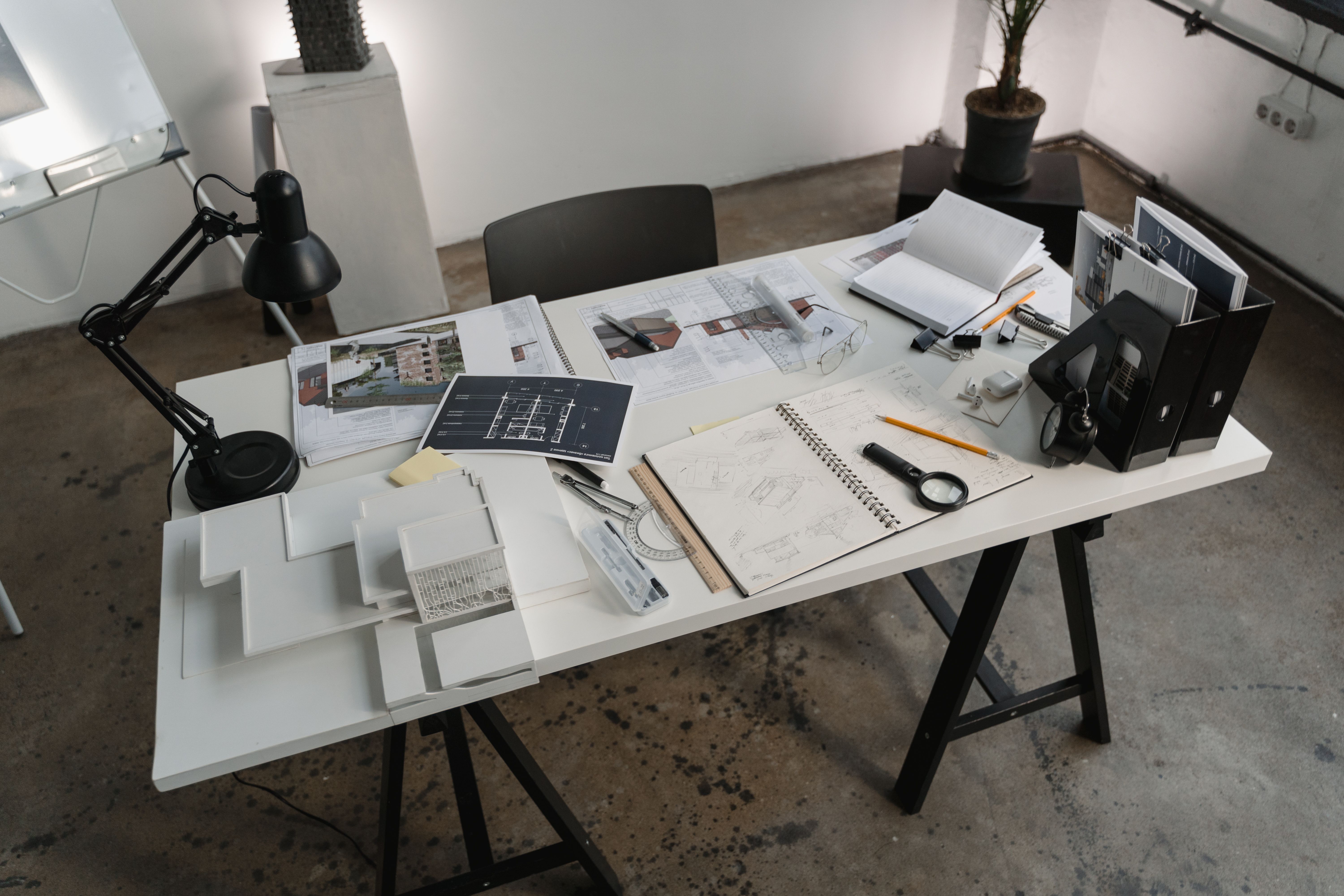 Home floor plans and closing documents on a white table, a checklist for closing on a house in New Hampshire