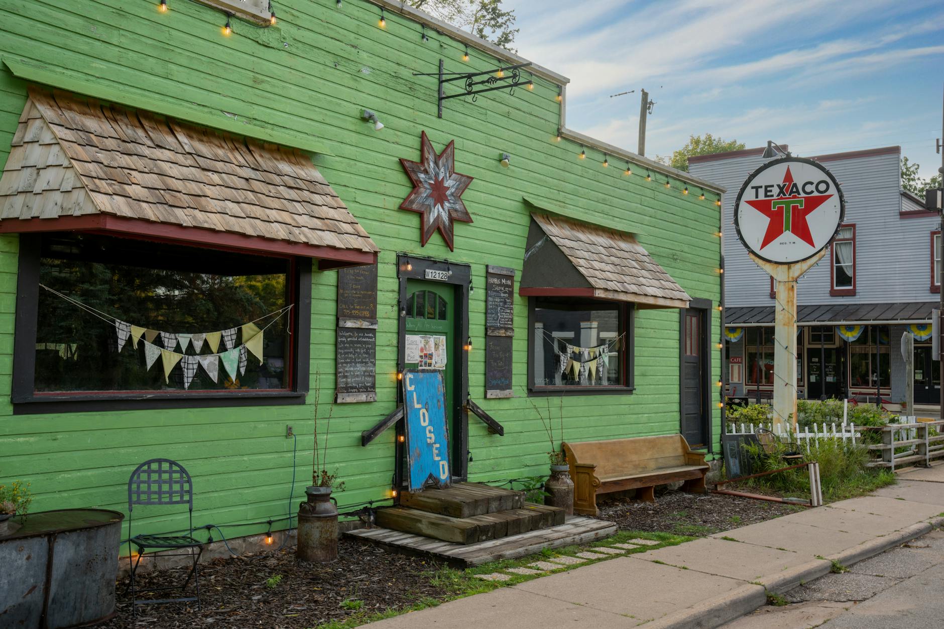 Vintage small-town storefronts with a weathered Texaco sign — the kind of village main-street character Penacook NH is known for
