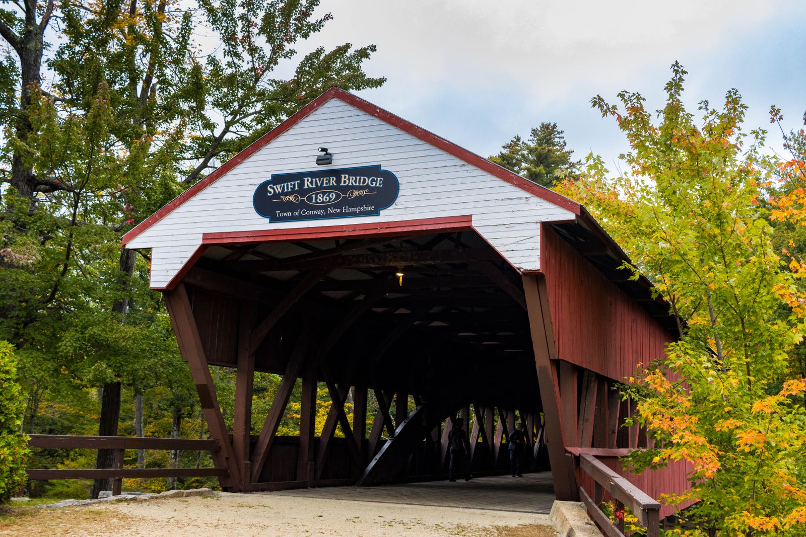 Swift River covered bridge in Conway New Hampshire framed by early-fall foliage - the outdoor lifestyle NH towns are known for
