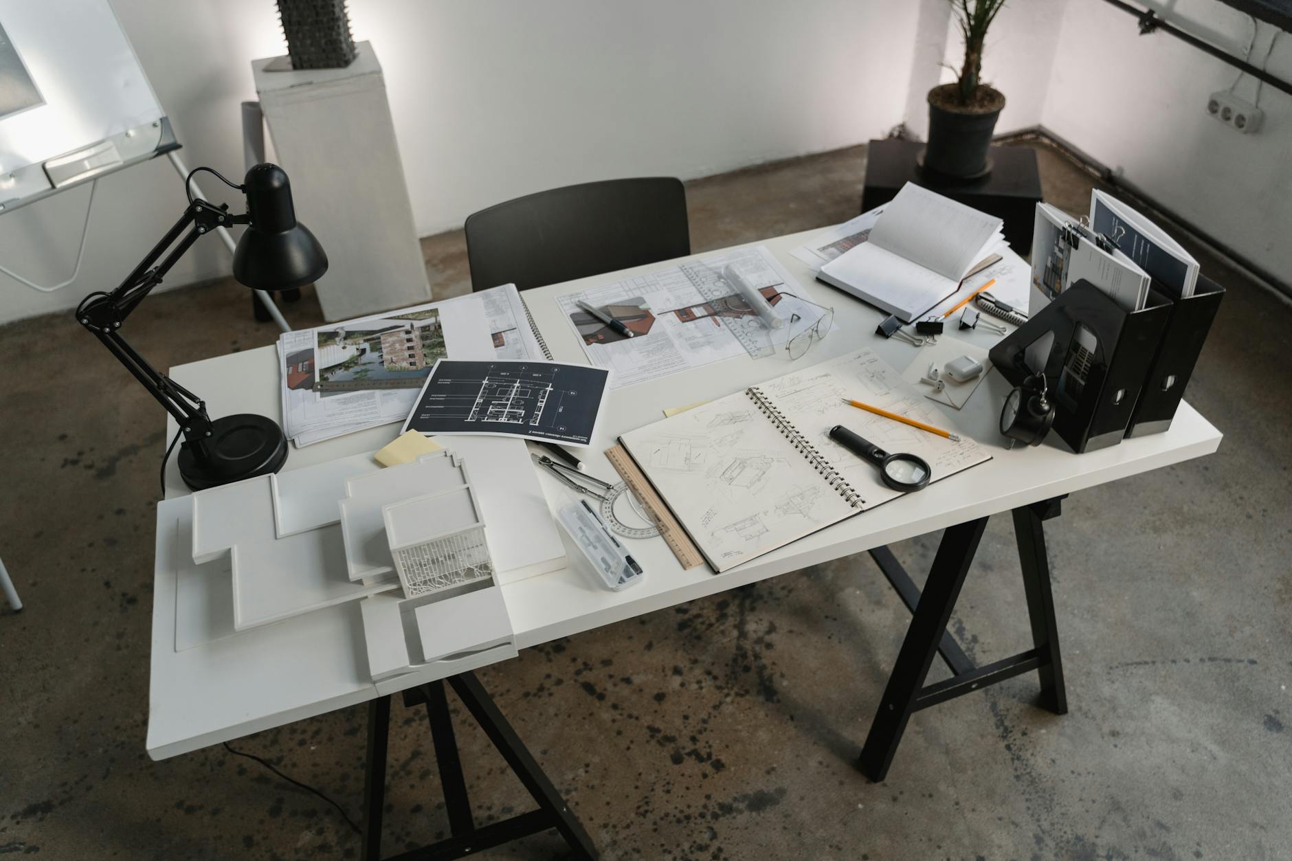 Architect's desk covered with home blueprints, sketches, a ruler and planning paperwork, evoking the documents reviewed in a New Hampshire purchase and sale agreement