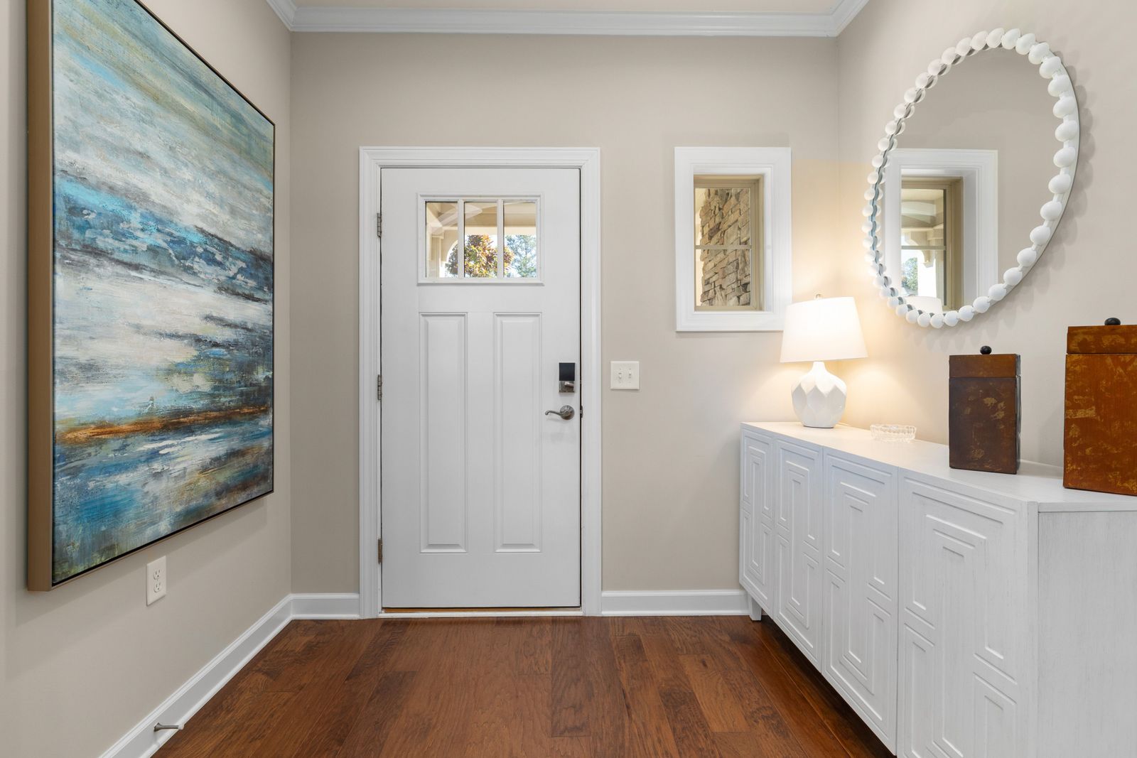 Bright home entryway with a white front door, hardwood floors and a console table, the first impression a pre-listing inspection protects when selling a NH home