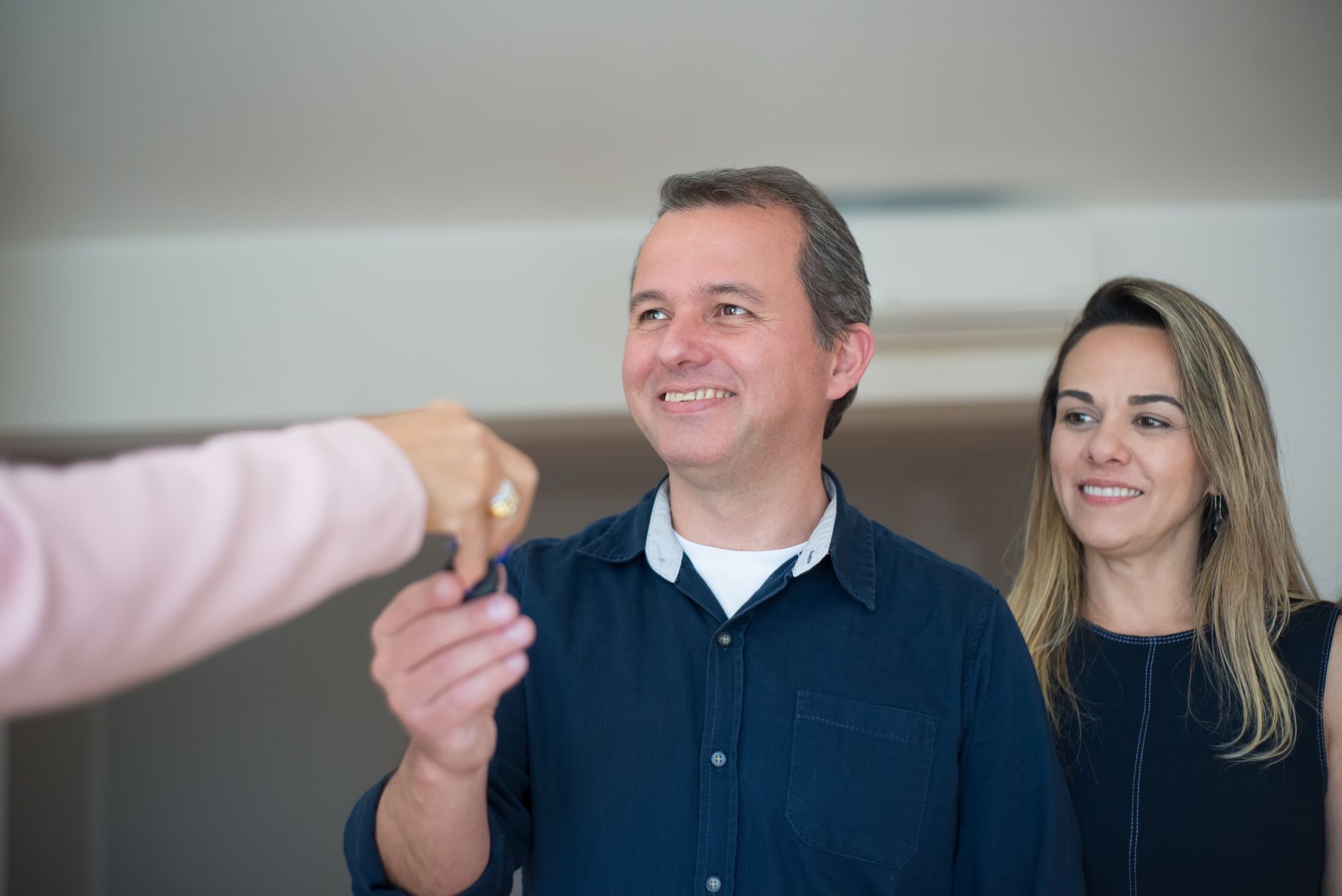 Smiling couple receiving the keys to their new home after negotiating their New Hampshire home purchase