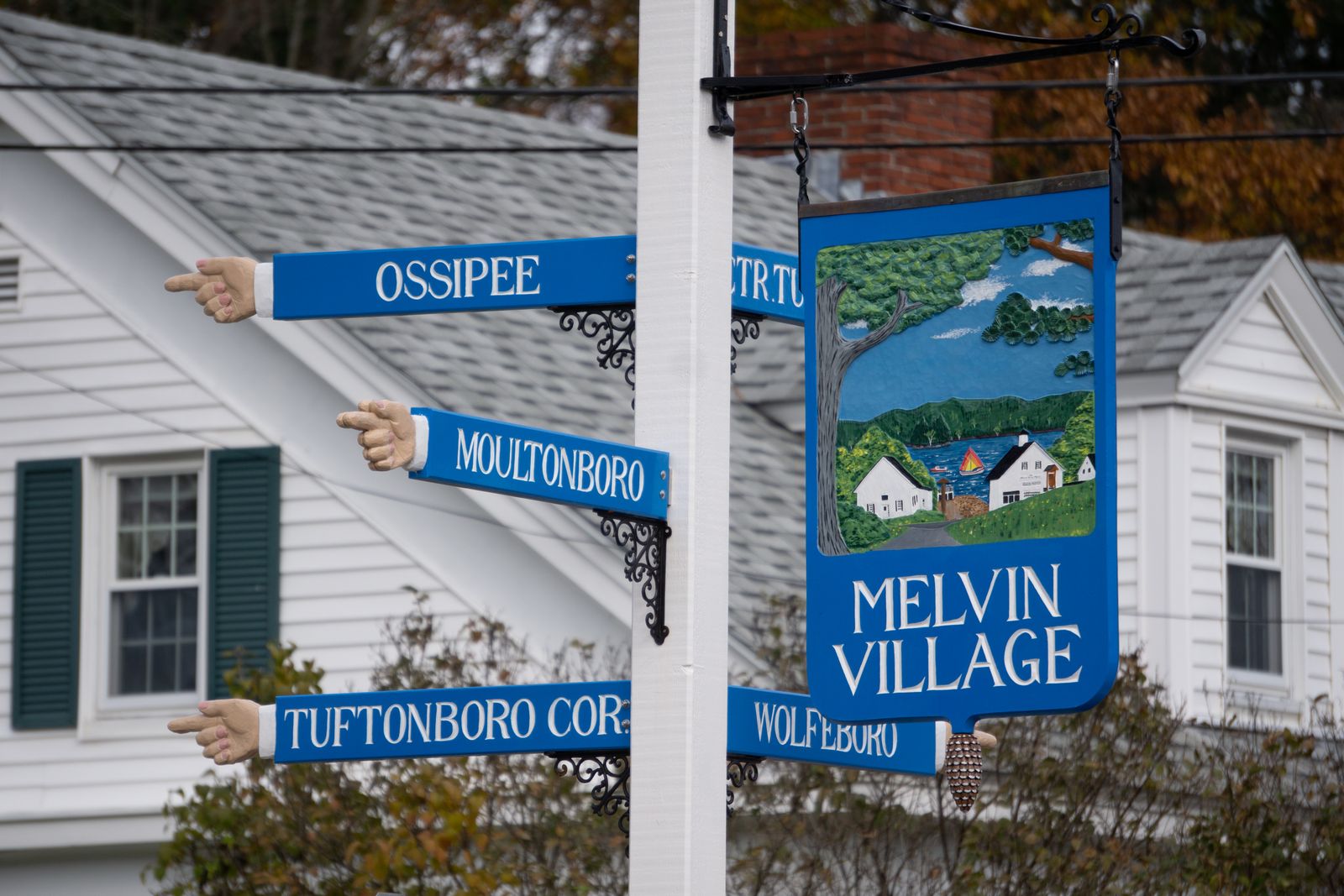 New Hampshire town direction signs against autumn foliage in the Lakes Region