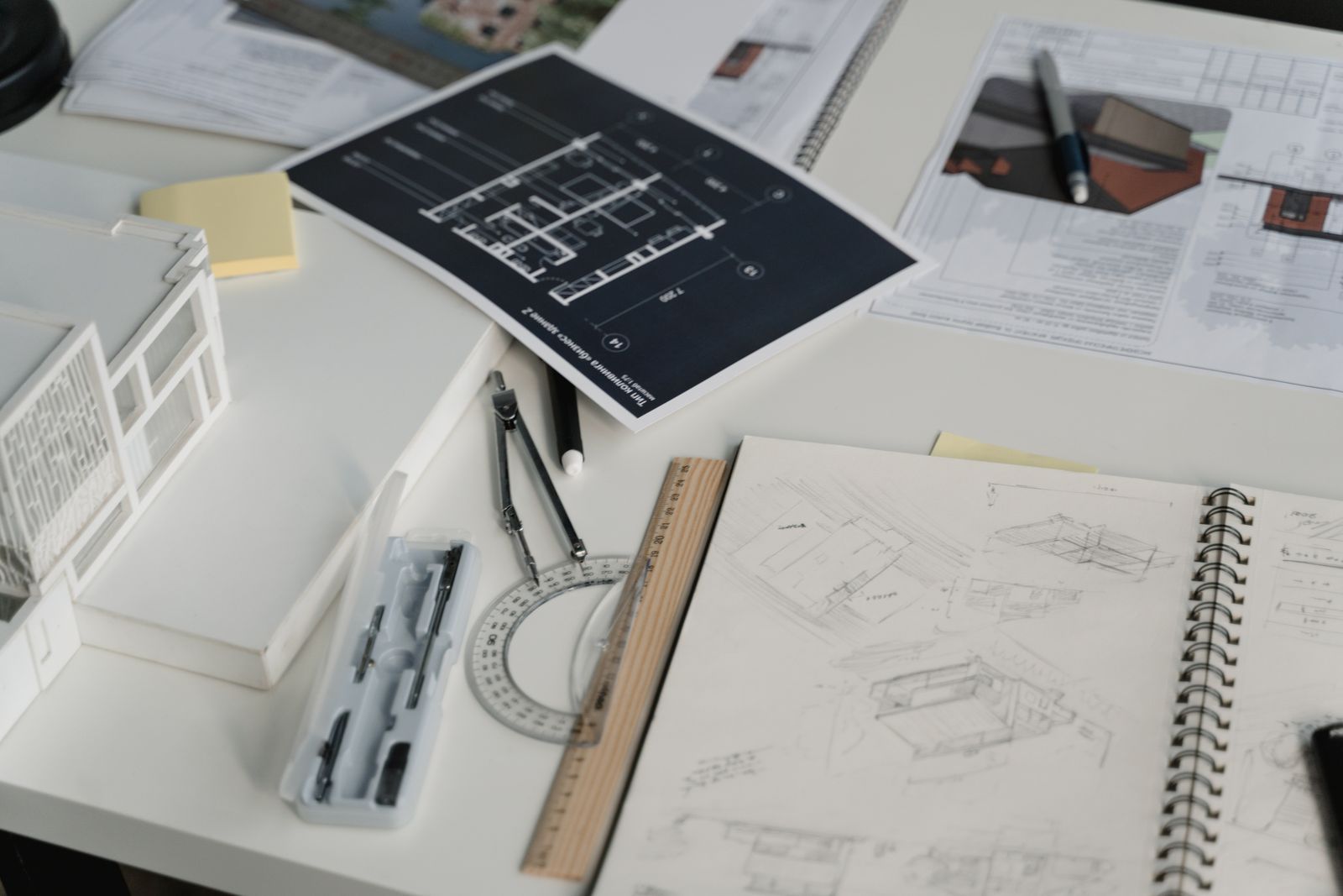 Printed plans and drawings spread over a work table, representing planning a New Hampshire home purchase