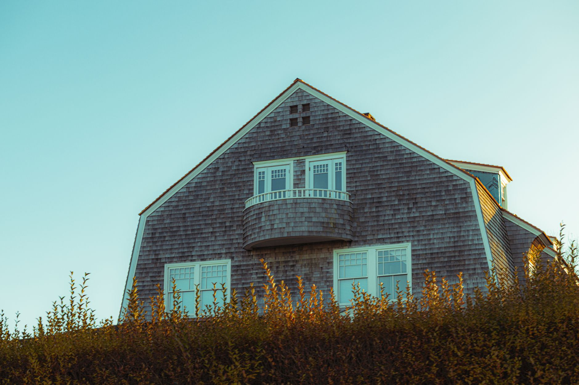 Shingle-style New England colonial home at golden hour, a look at the best neighborhoods in Milford NH